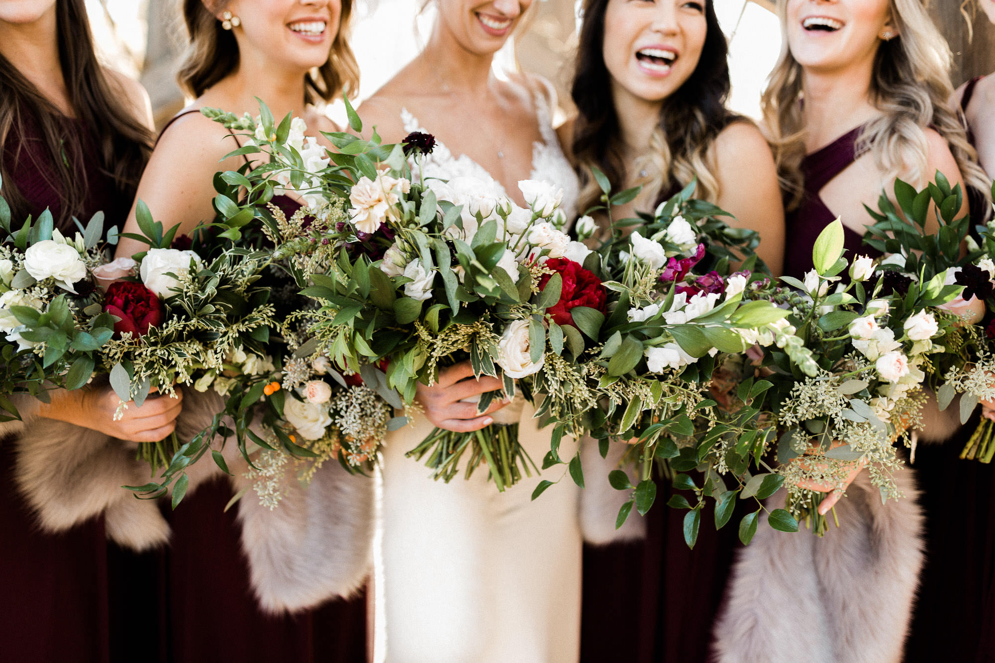 Bride and bridesmaids hold bouquets and laugh at Brasada Ranch in Bend, Oregon