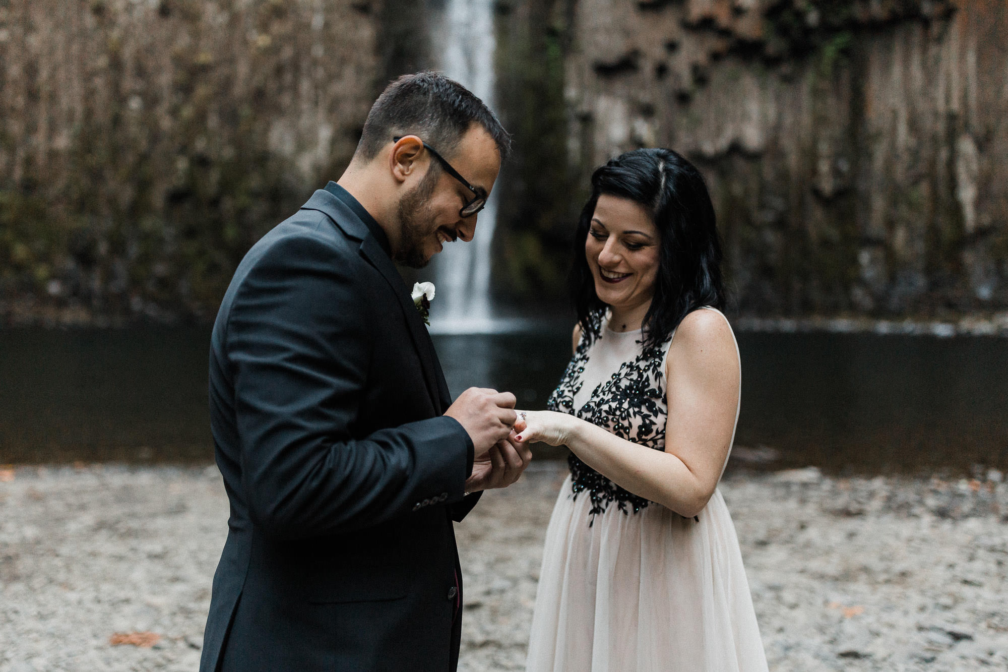 Groom places ring on bride's finger at Abiqua Falls, Oregon