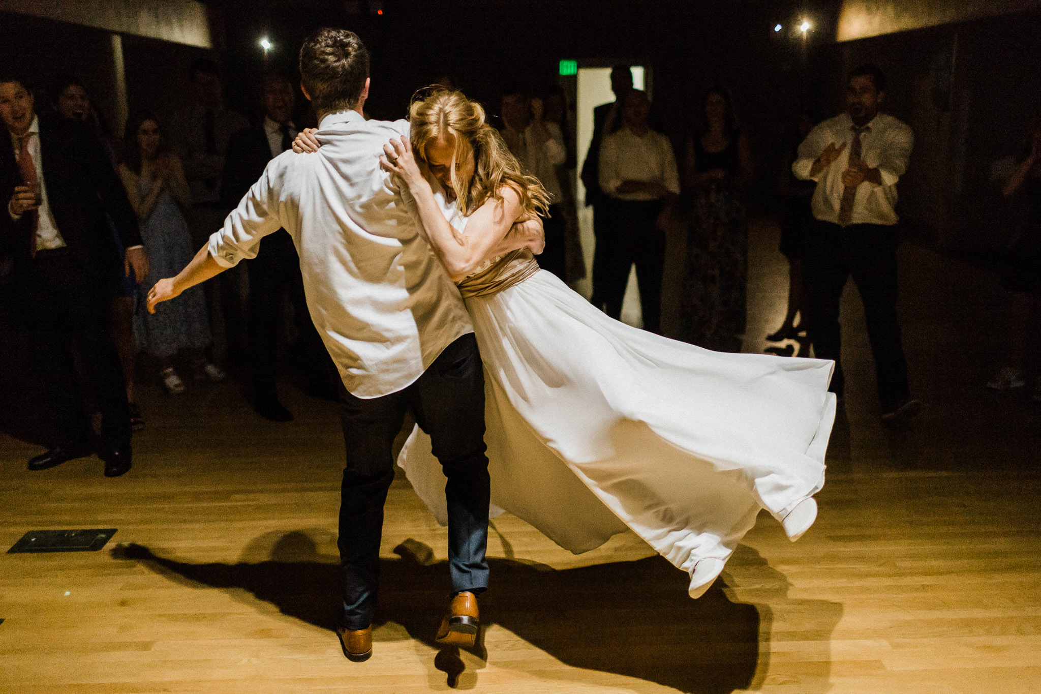 Groom spins bride through the air on dance floor at Lewis and Clark College in Portland, Oregon