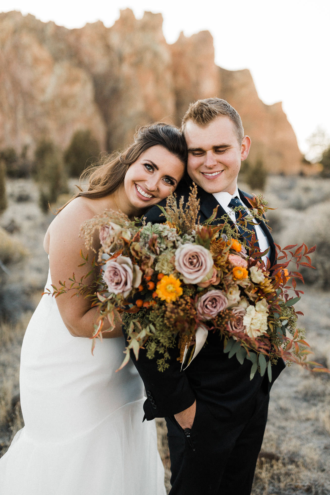 Bride embraces groom at Smith Rock State Park, Oregon