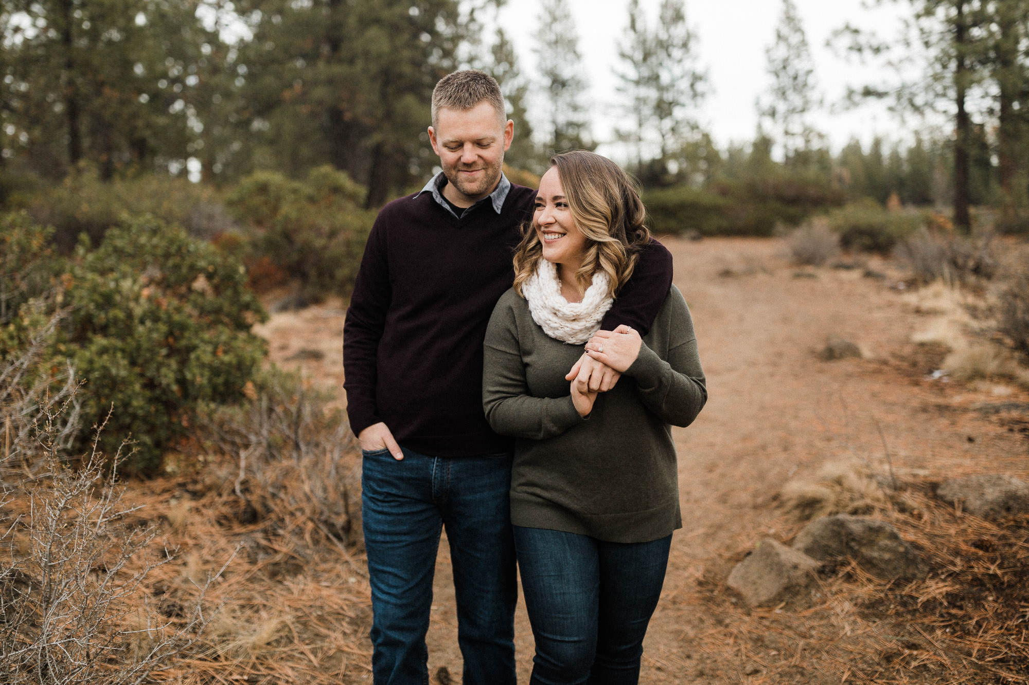 A couple holds hands as they walk on a trail in Bend, Oregon 