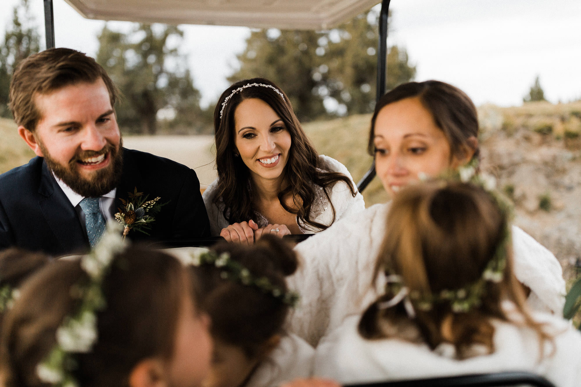 Bride and groom laugh at young nieces riding in golf cart at Pronghorn Resort in Bend, Oregon