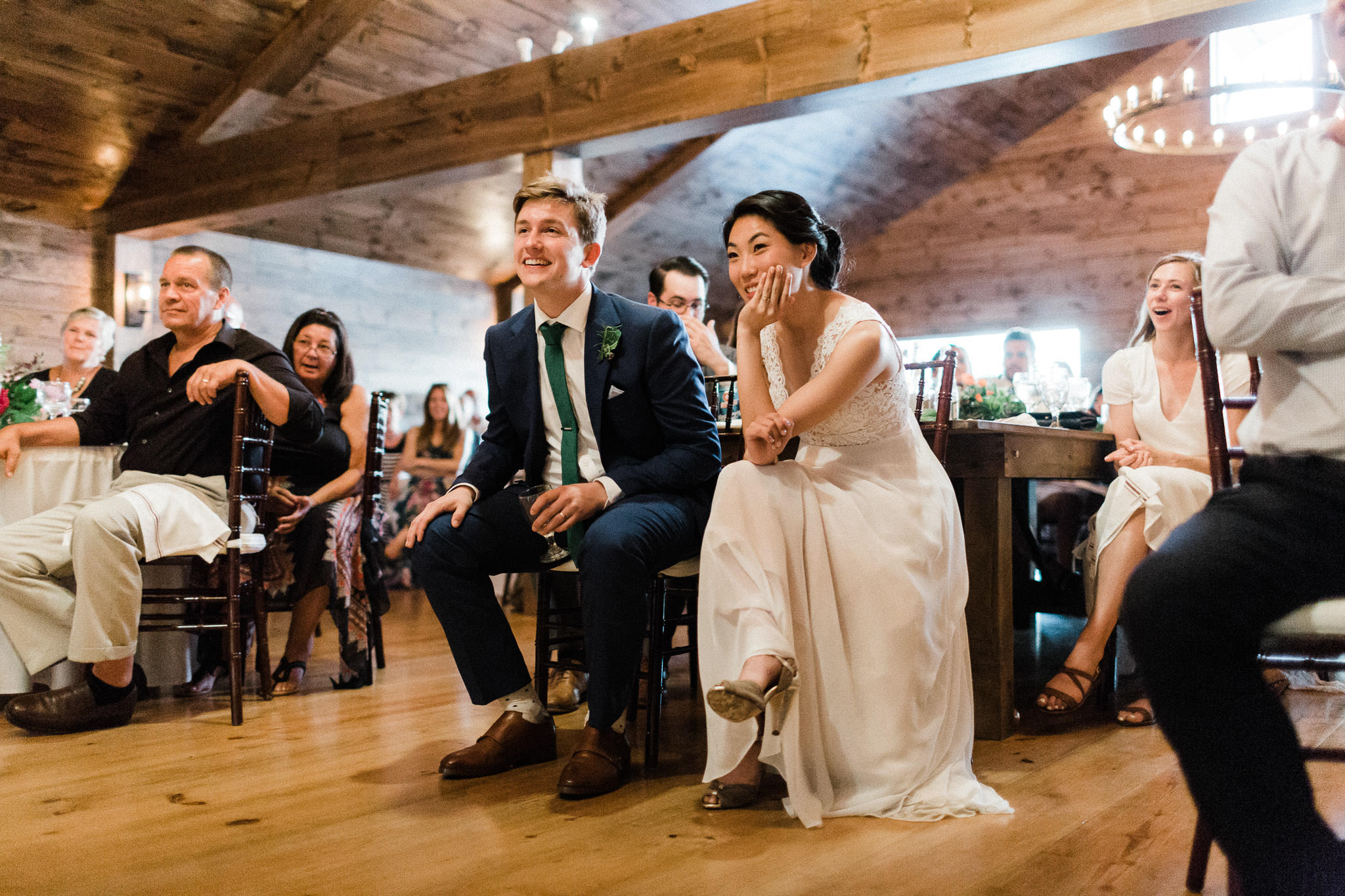 Bride and groom listen to speech at Bomoseen Lodge in Vermont