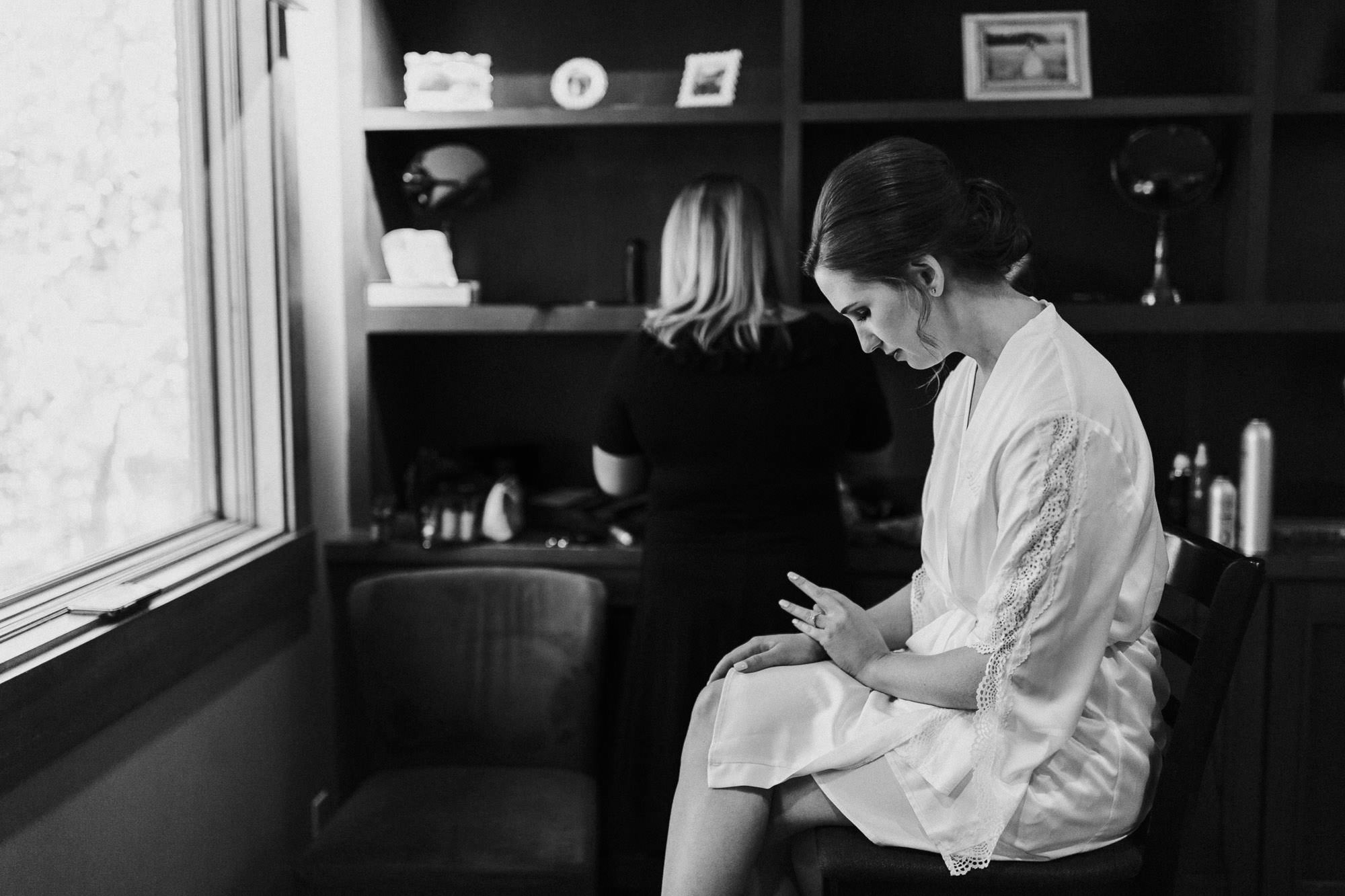 Bride looks at her ring while getting makeup done at Black Butte Ranch