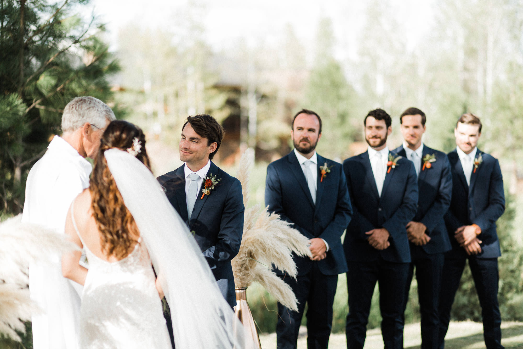 Groom smiles during wedding ceremony at Broken Top Club in Bend, Oregon