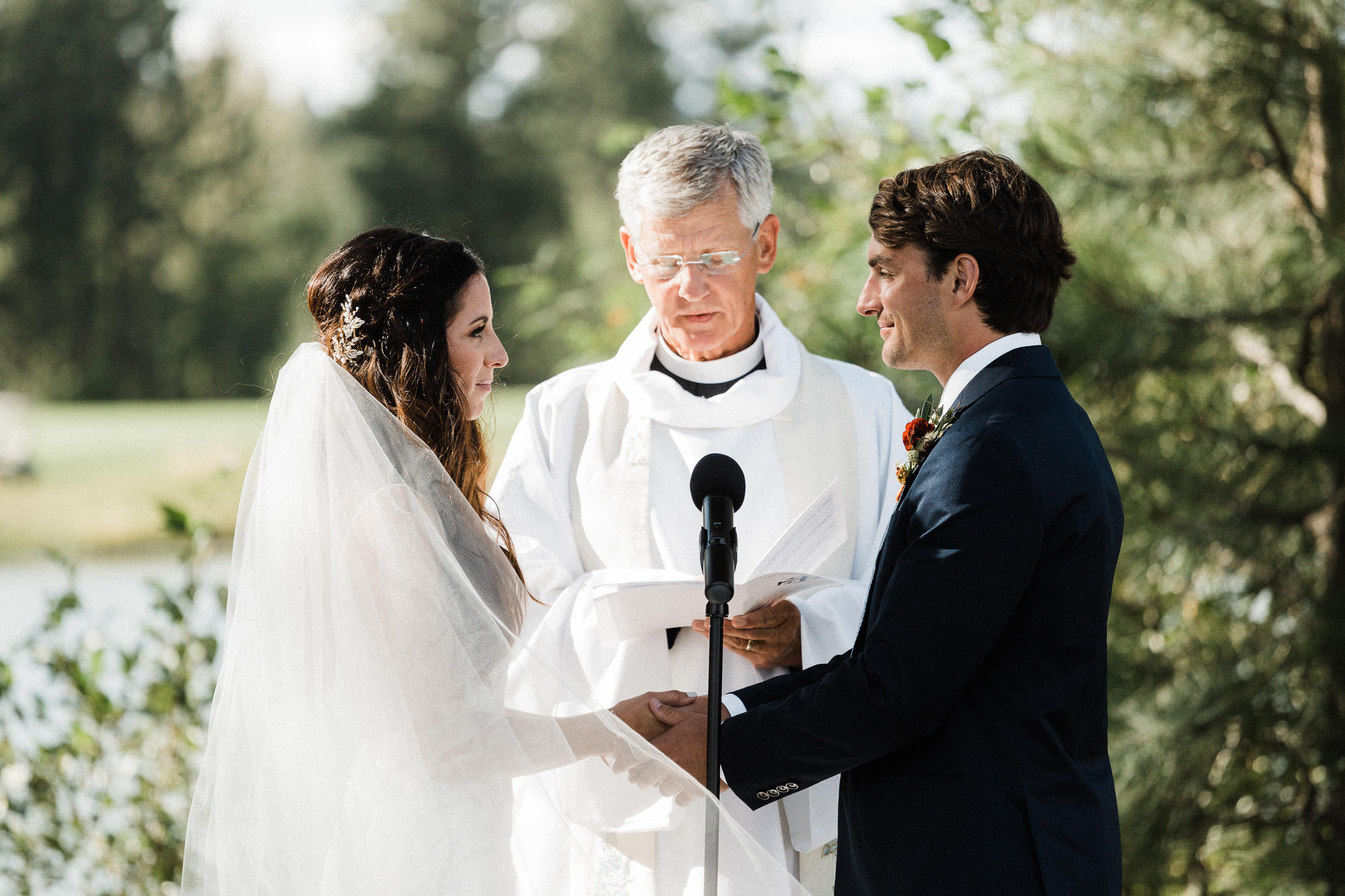 Bride and groom hold hands during wedding at Broken Top Club in Bend, Oregon