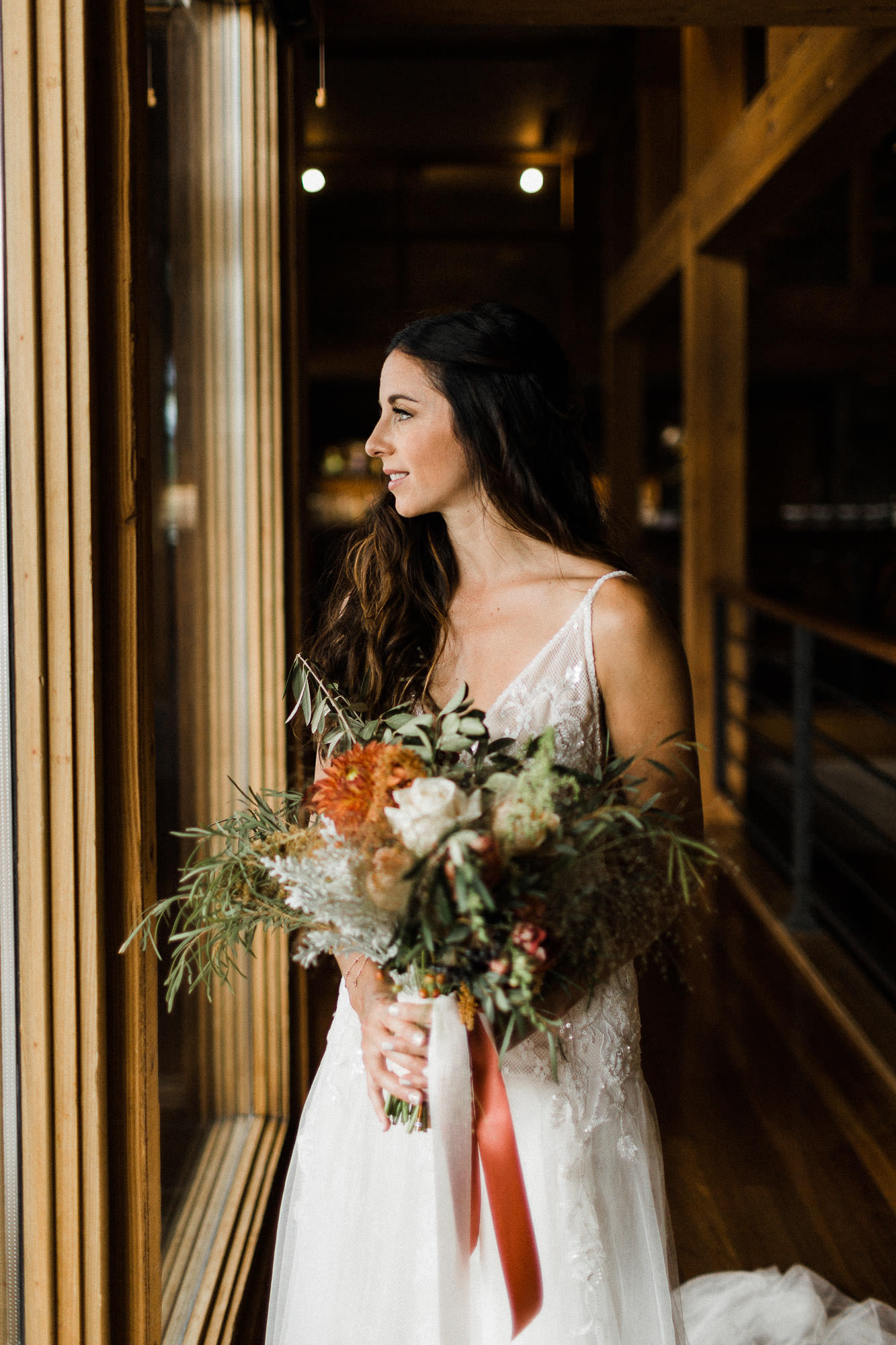 Bride gazes out a window at Broken Top Club in Bend, Oregon