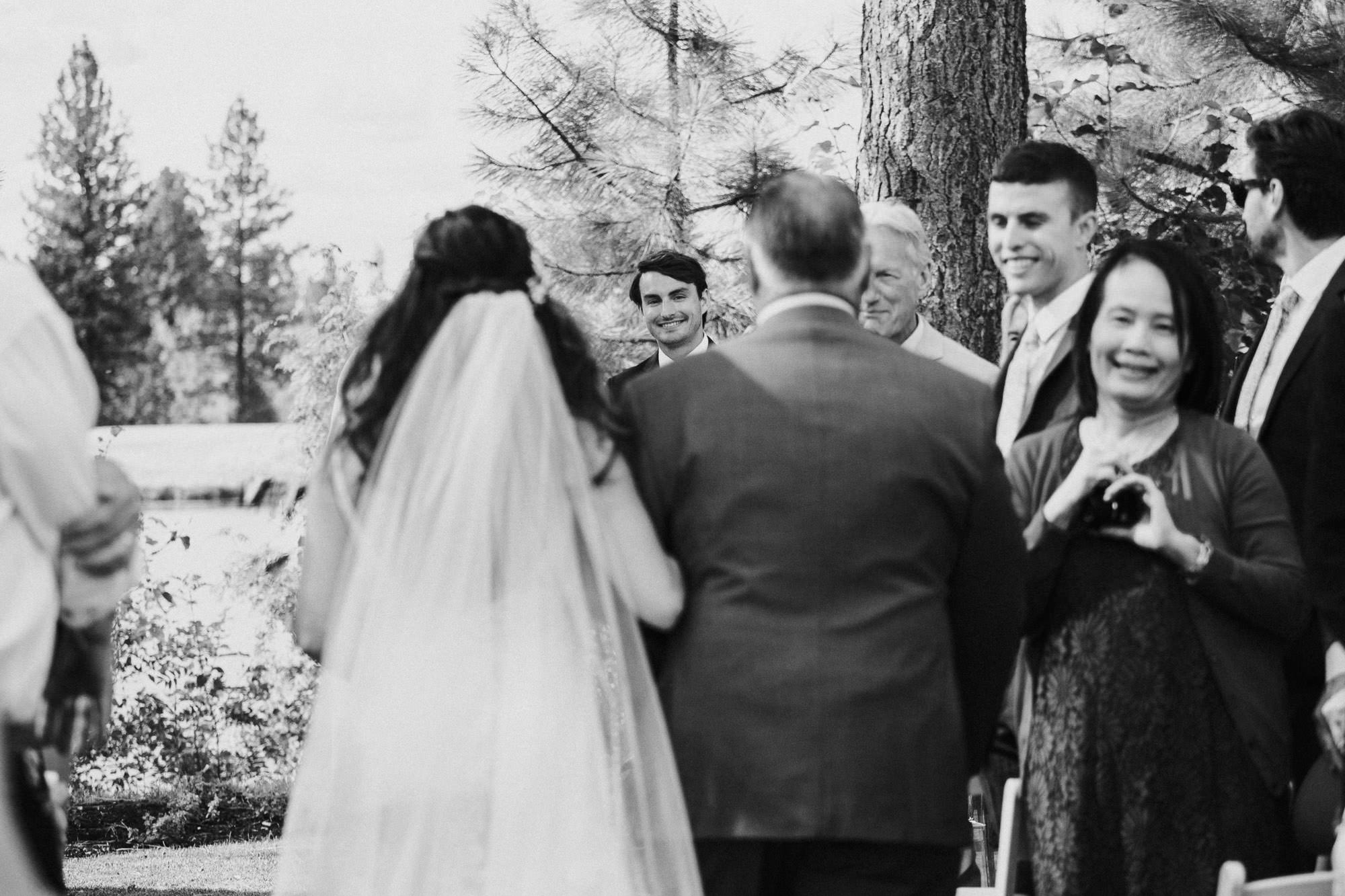 Groom watches bride walk down the aisle at Broken Top Club in Bend, Oregon