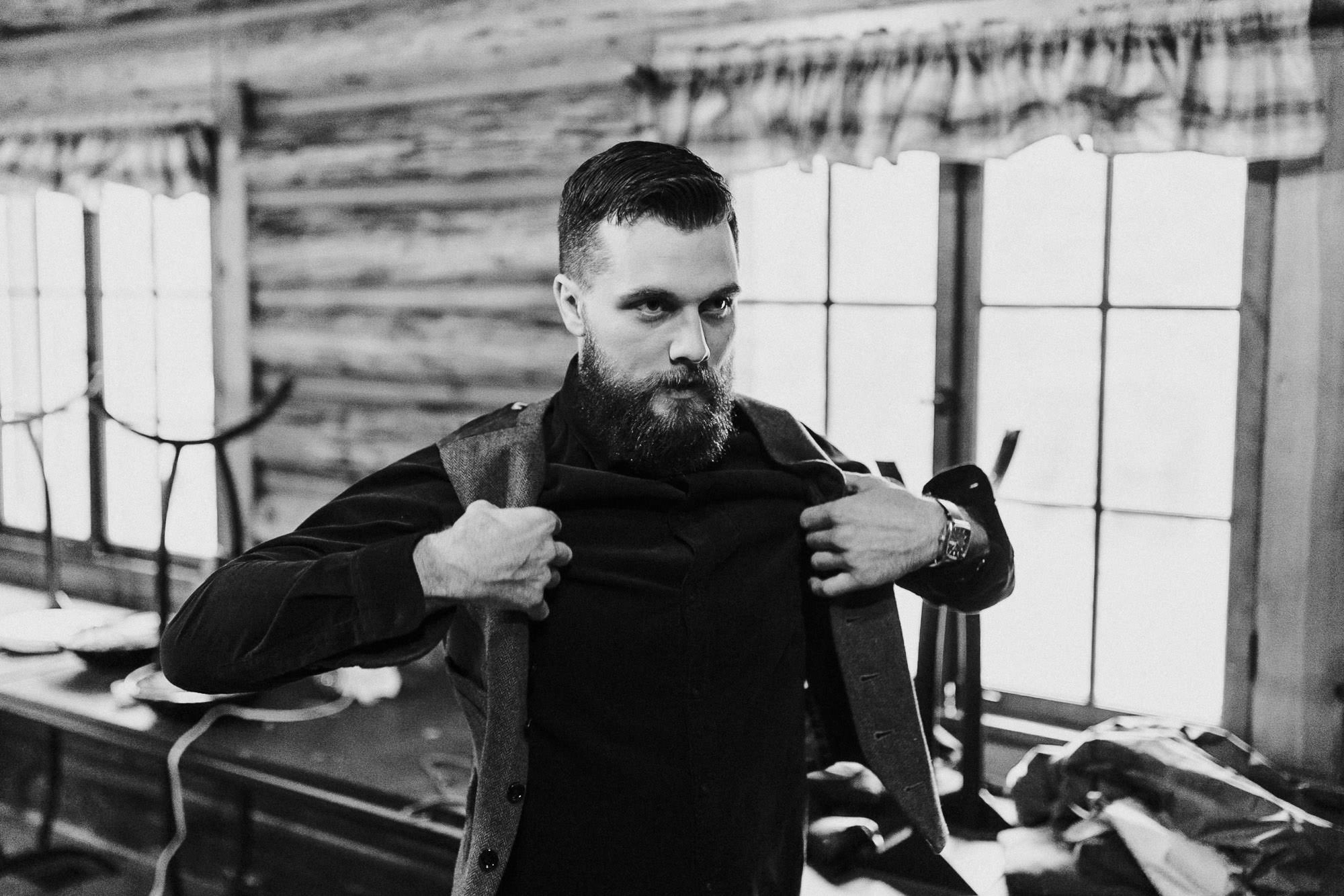 Groom puts on his vest at Skyliner Lodge in Bend, Oregon