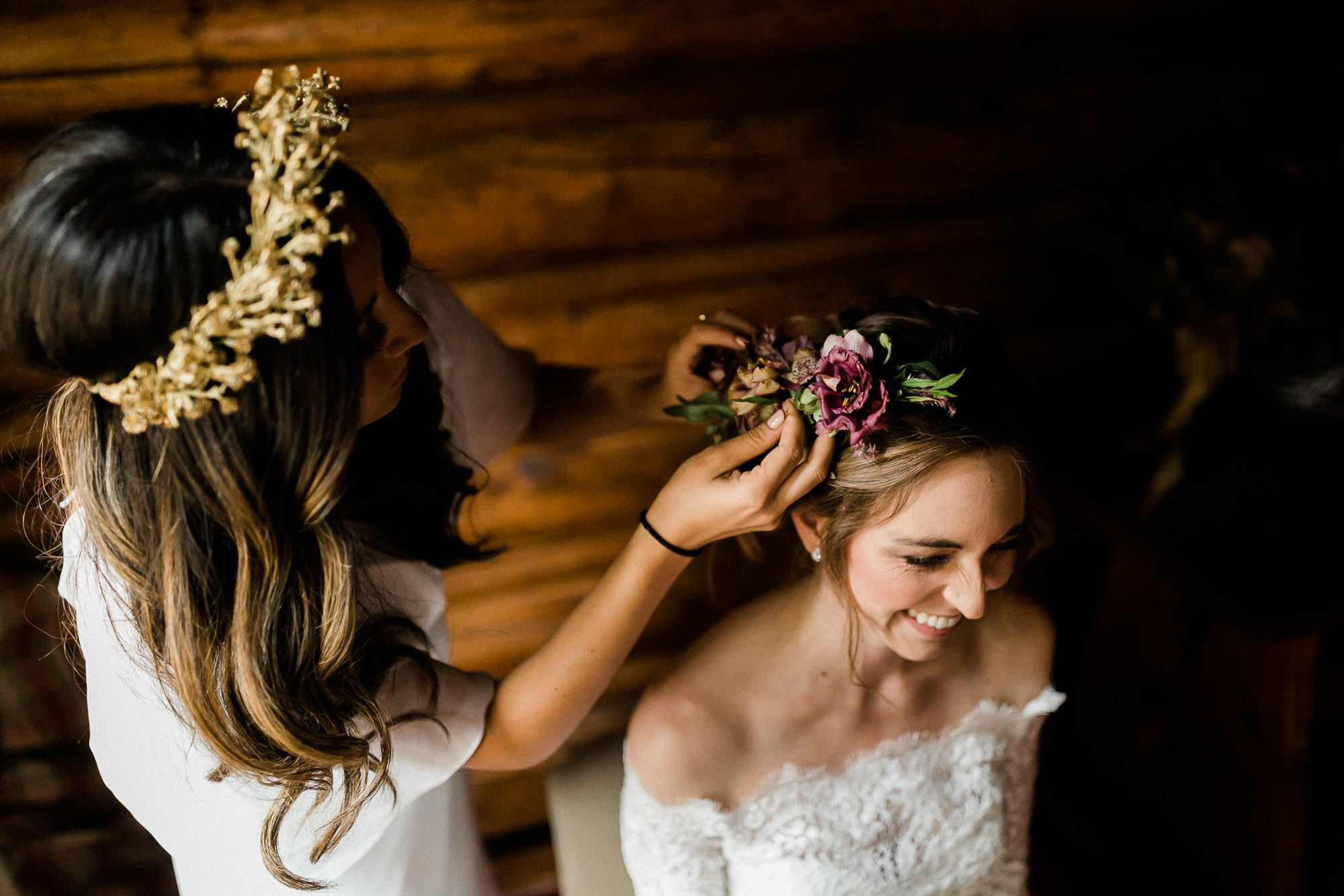 Maid of honor places floral hairpiece in bride's hair at Skyliner Lodge