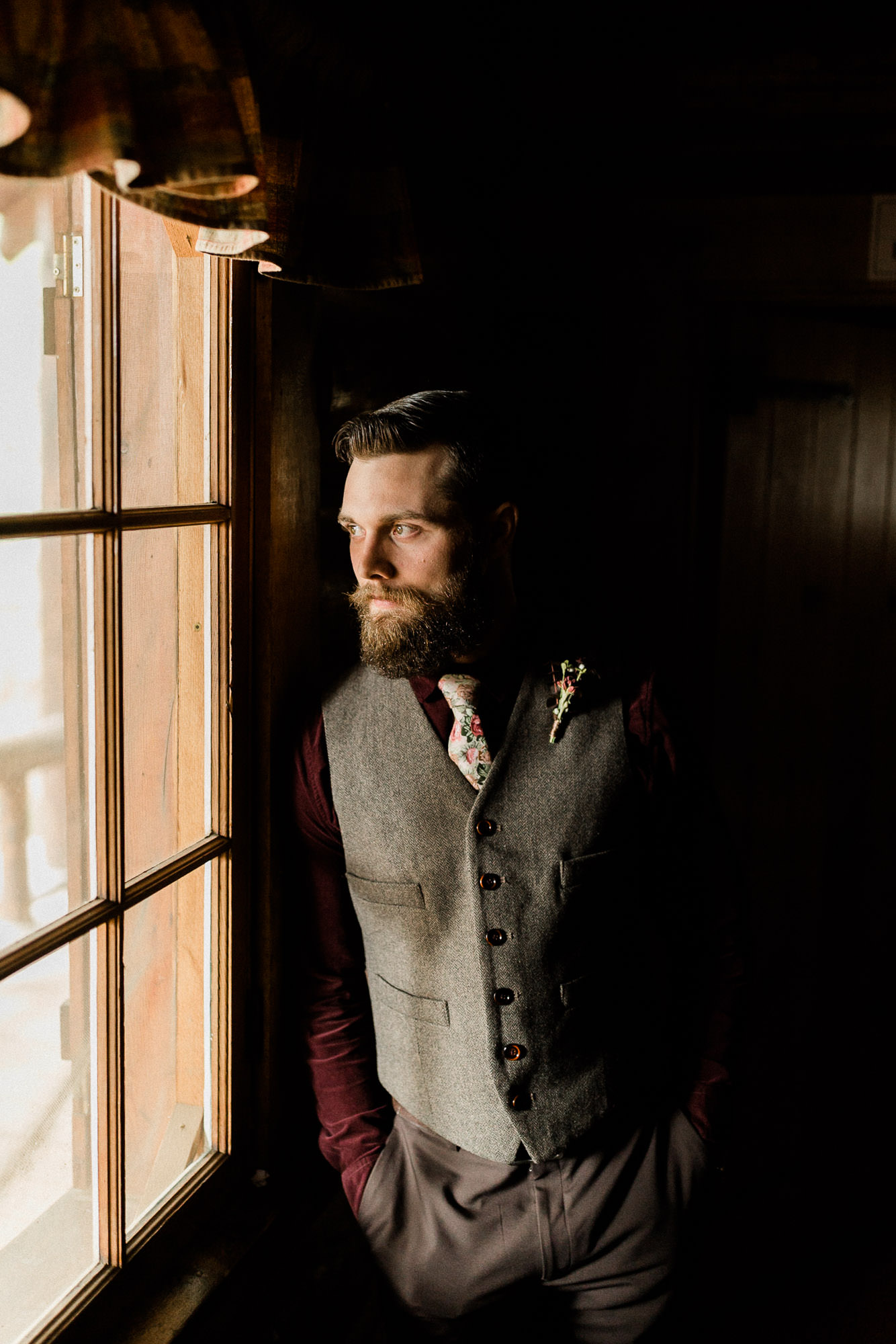 Groom looks out the window at Skyliner Lodge in Bend, Oregon
