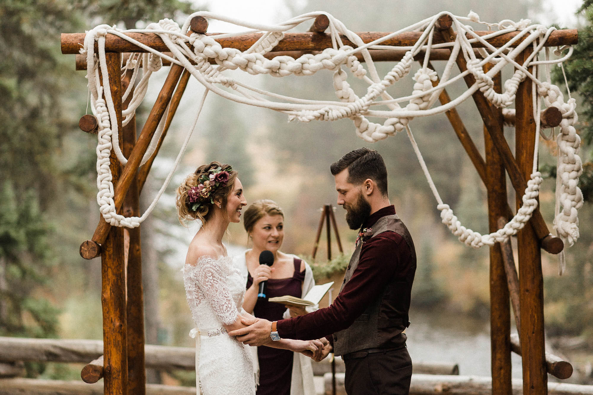 Bride and groom smile during ceremony at Skyliner Lodge
