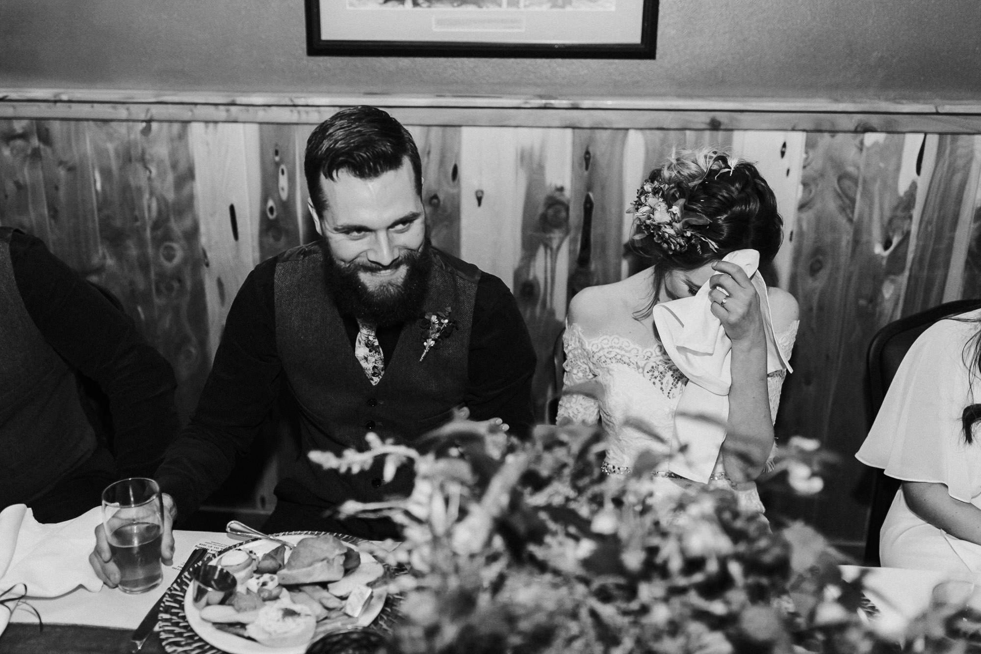 bride and groom laugh and react to toasts at Old St. Francis School