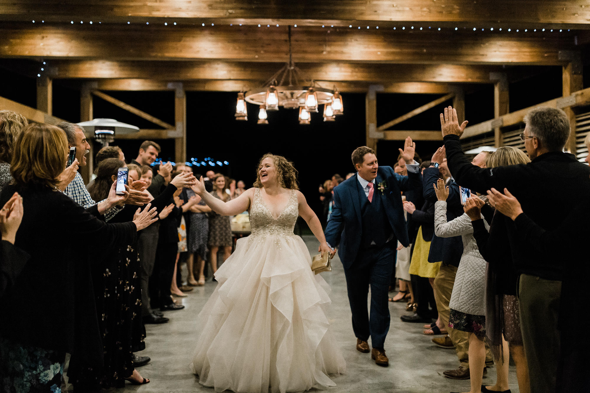 The bride and groom high-five guests as they make their grand exit at Mt. View Orchards.