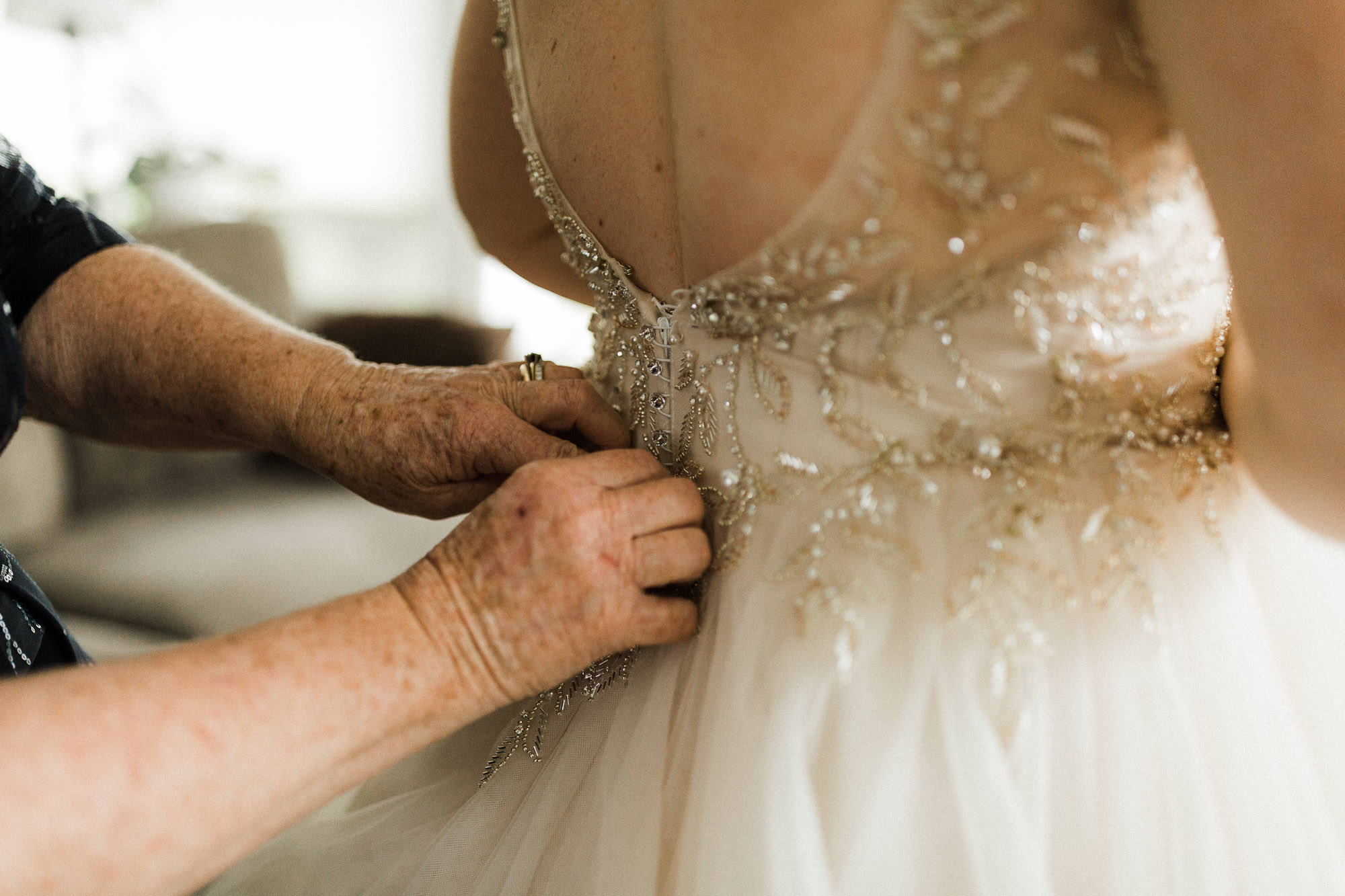 The bride's mother buttons up the bride's wedding dress in Mt. Hood, Oregon.