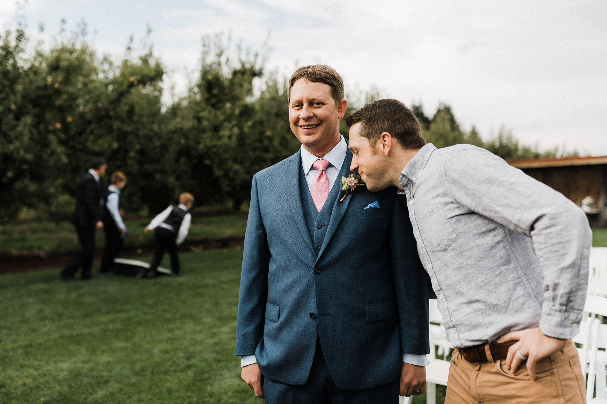 A guest leans in and smells the groom's boutonniere at Mt. View Orchards.