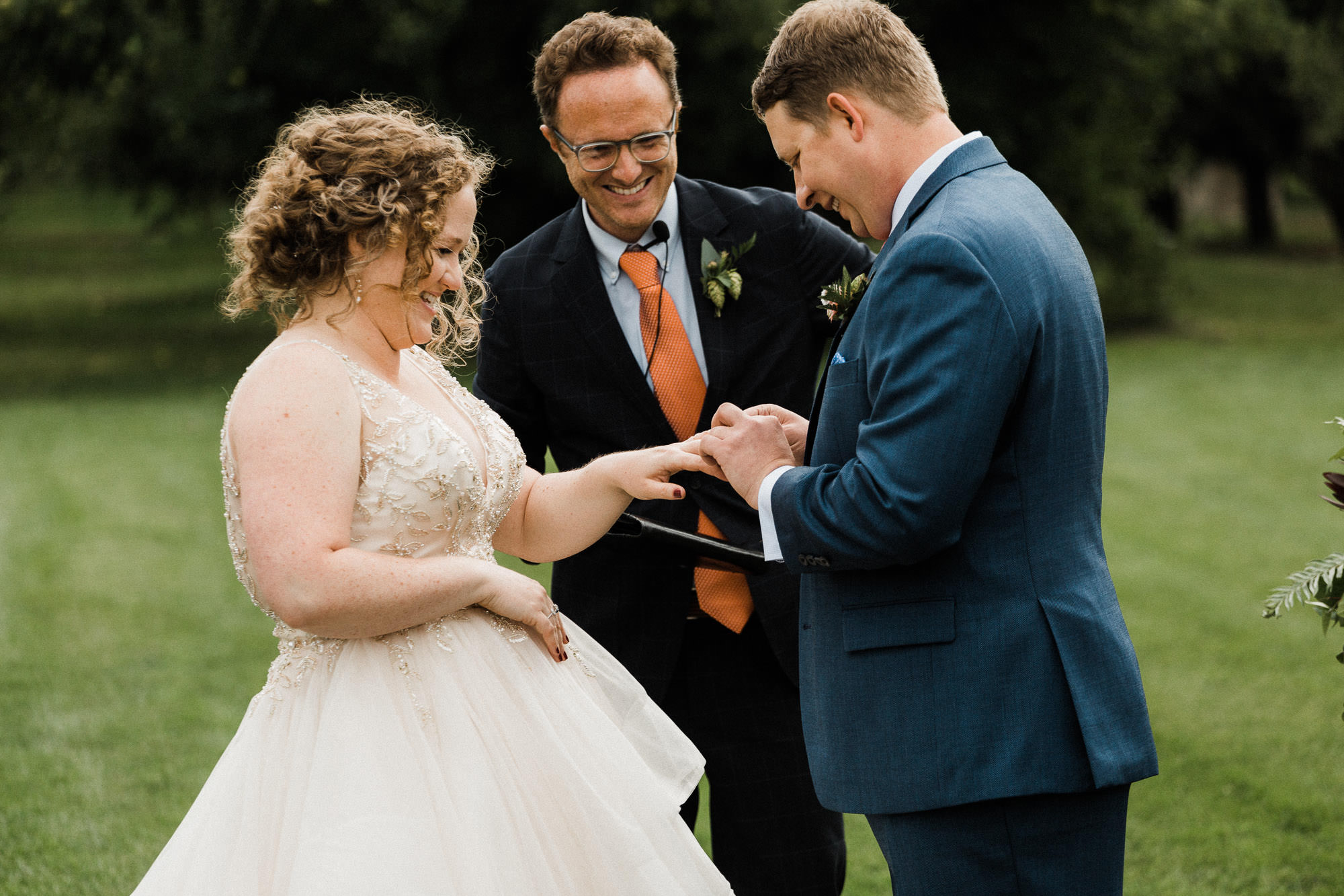 The groom places a ring on the bride's finger at Mt. View Orchards in Oregon.