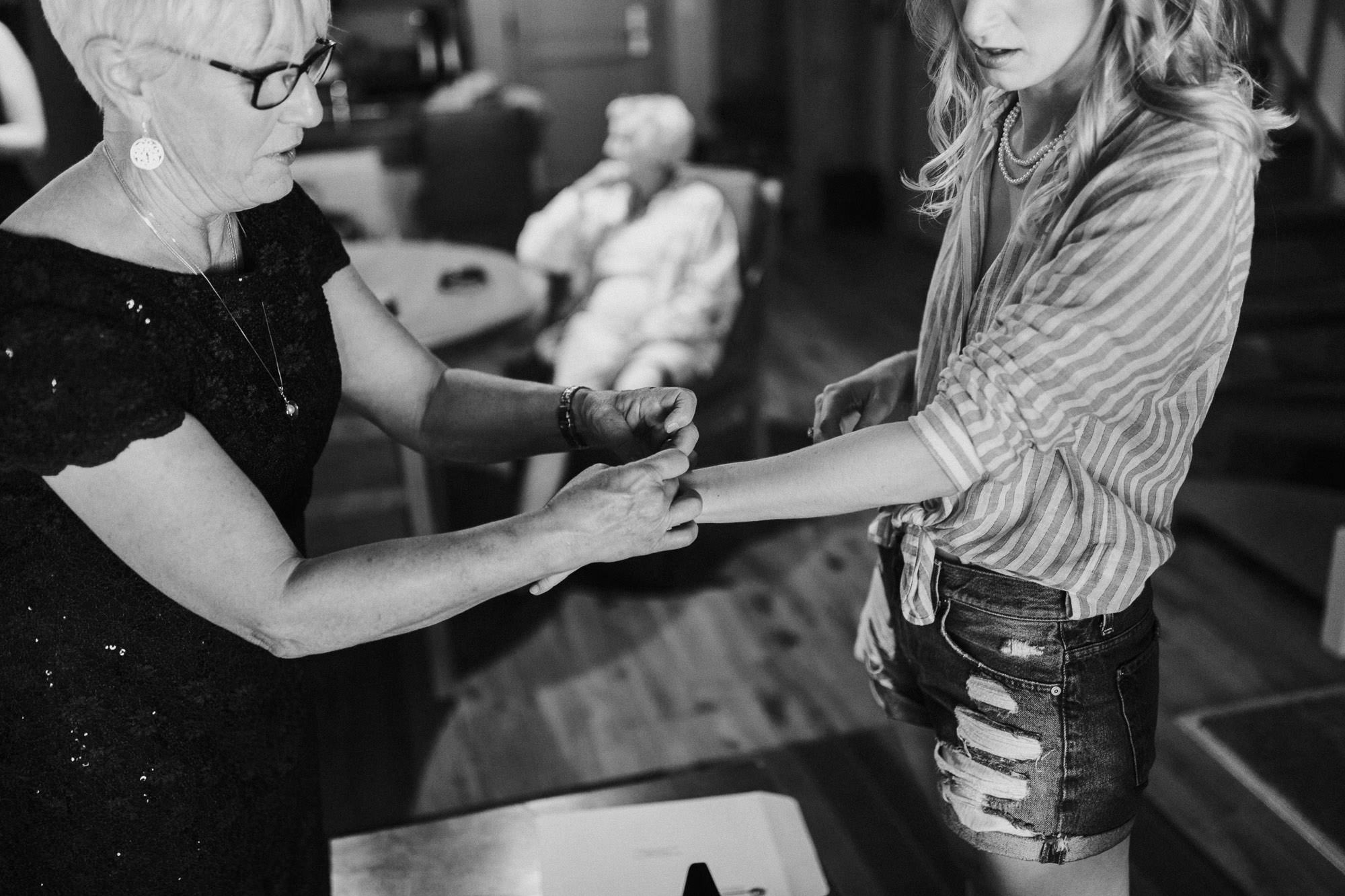 The bride's mother helps the bride put a bracelet on at Sunriver Resort