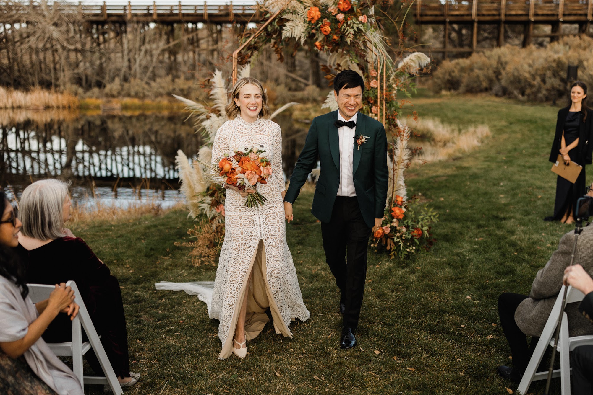 The bride and groom walking down the aisle together as they hold hands and walk passed their guests.