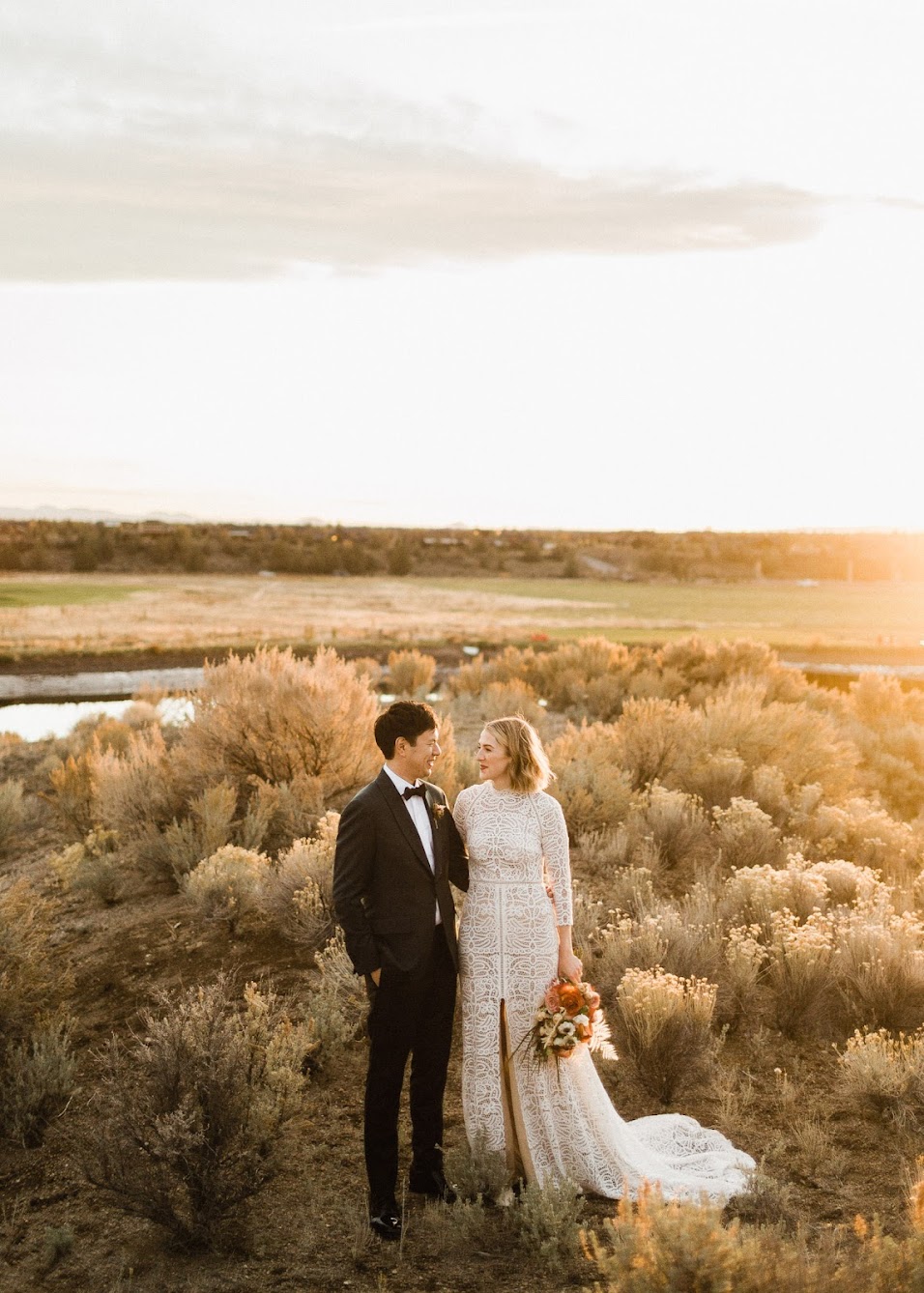 Bride and groom looking at each other with the sunsetting 
