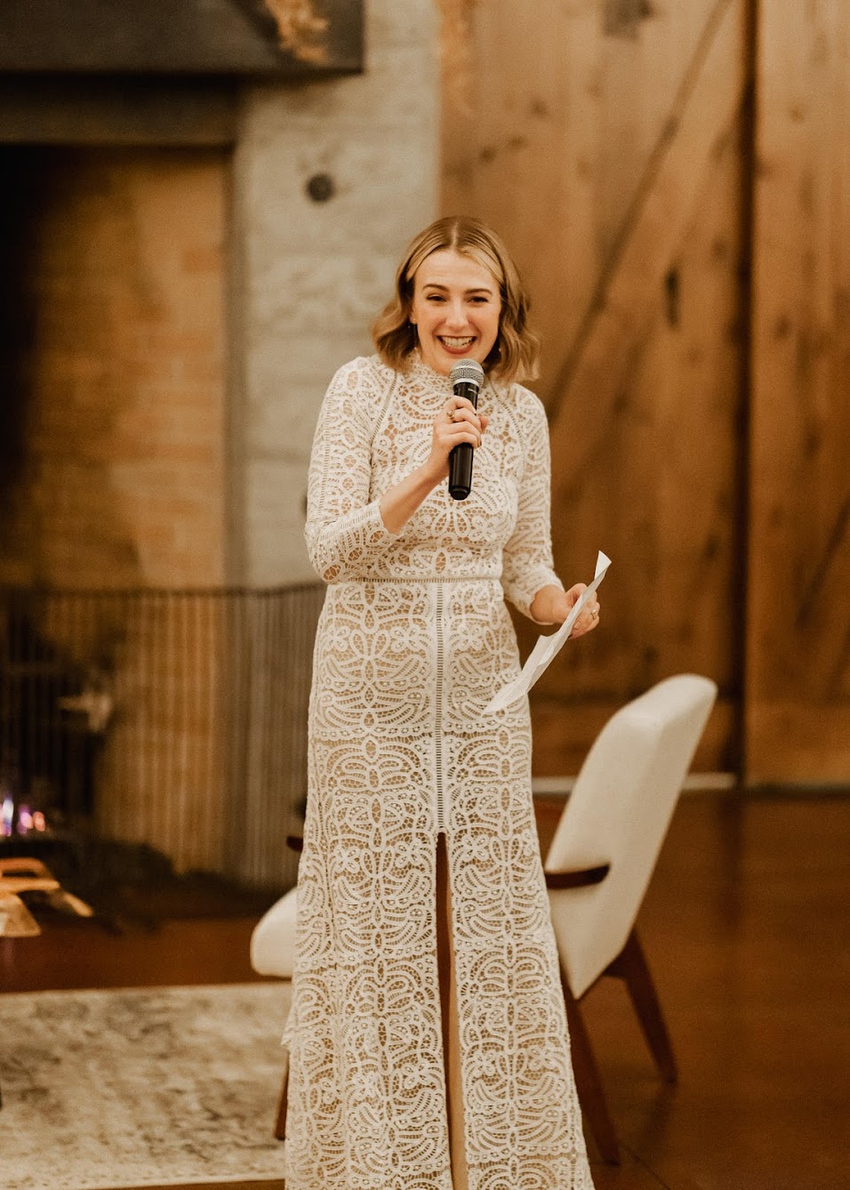 The bride standing up giving a speech, laughing.