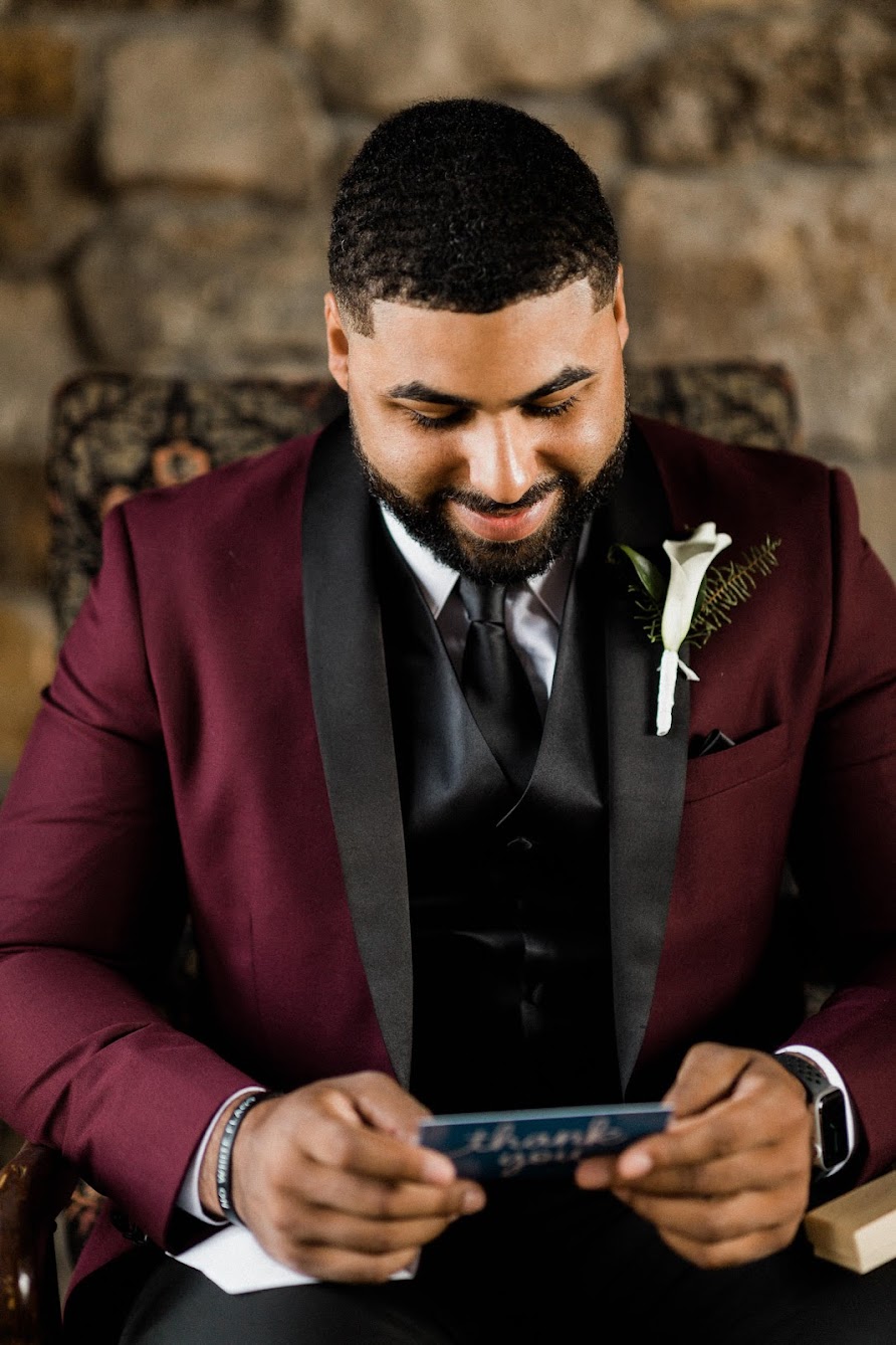 Gentlemen sitting down in his suite while ready a letter 