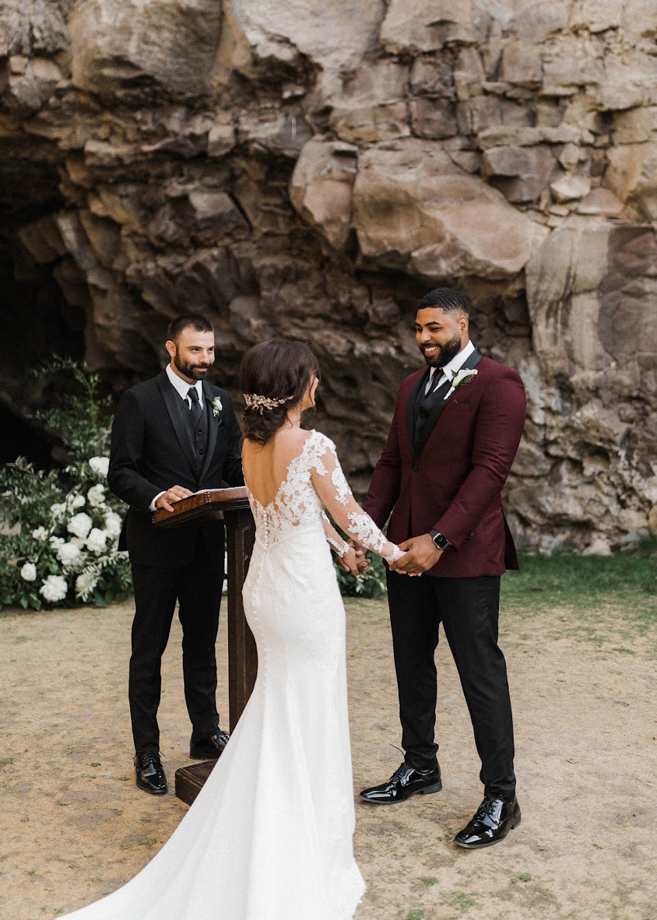 the groom looks into the bride's eyes, smiling and holding her hands. 