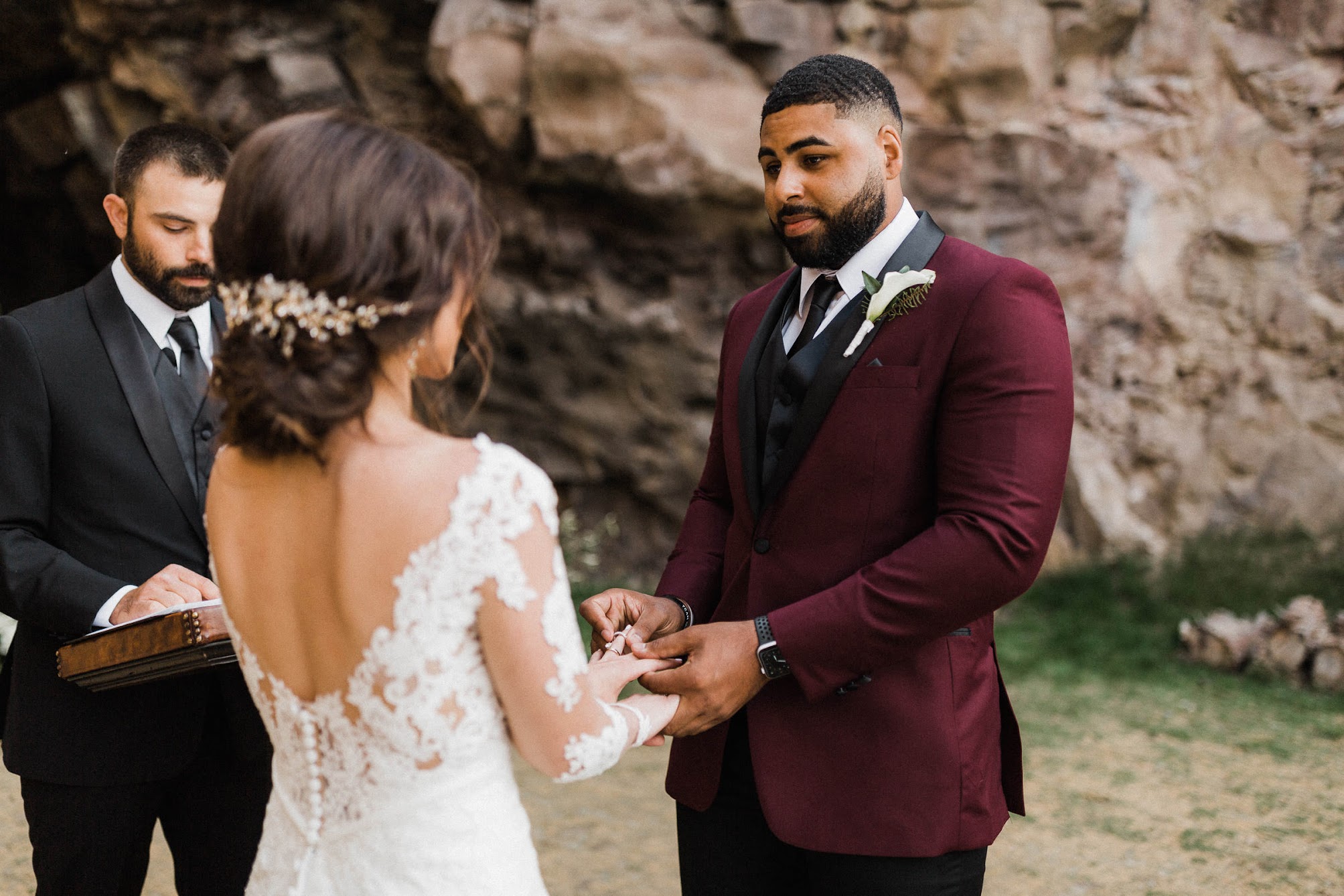the grooming looking into her eyes while he puts a ring on her finger