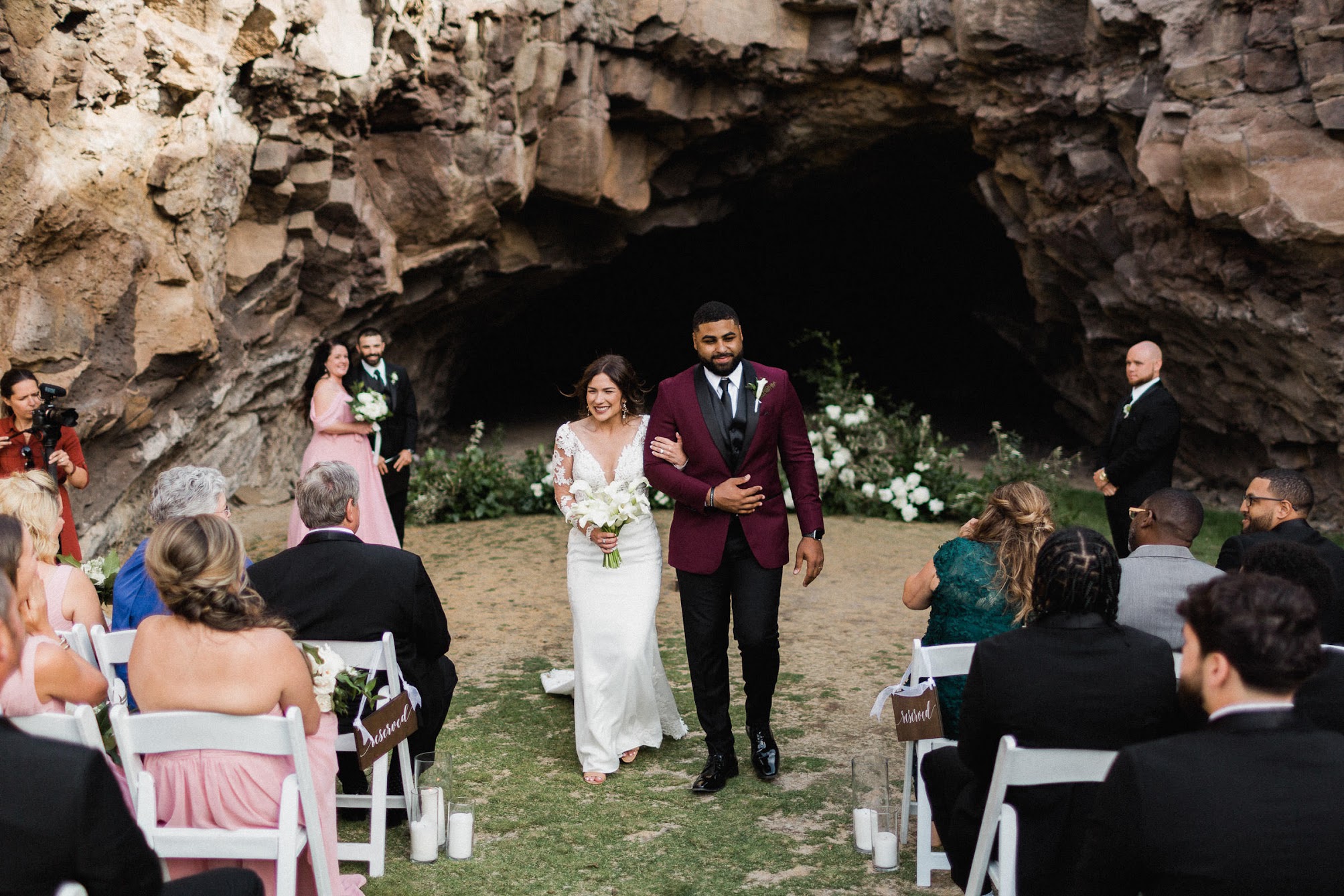 the couple walking down the aisle together with their arms locked, and the biggest smiles on their faces.