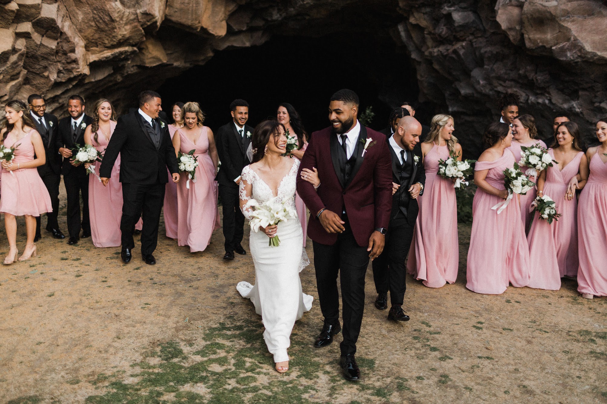 bride and groom walking in front of their bridal party. 
