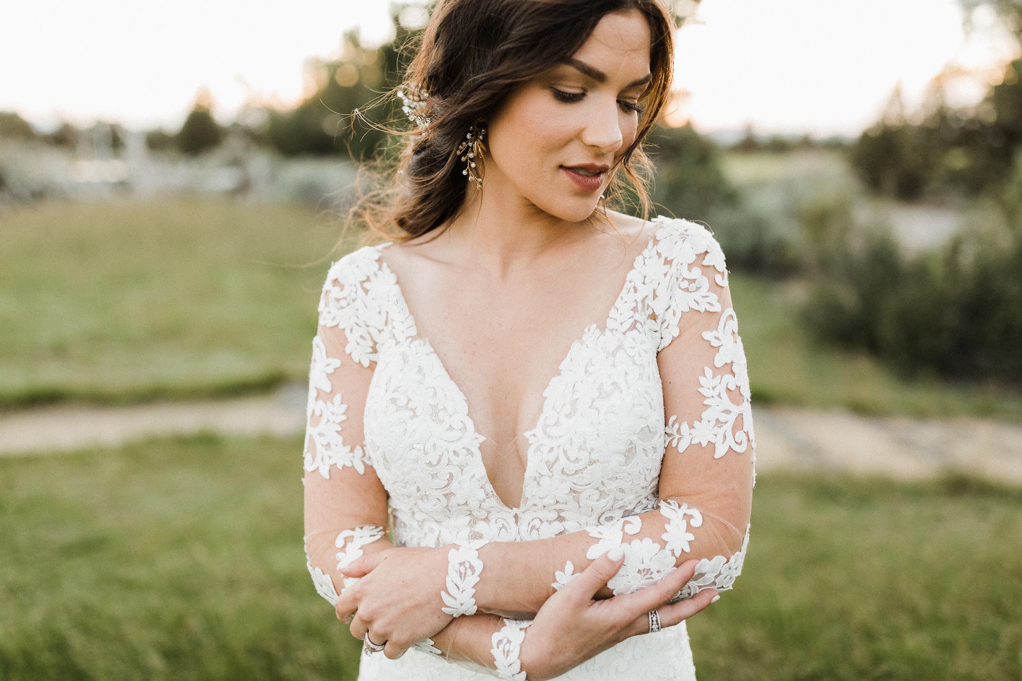 Up close of the wedding dress. stunning mesh sleeves with lace around the arms with a deep V cut. 