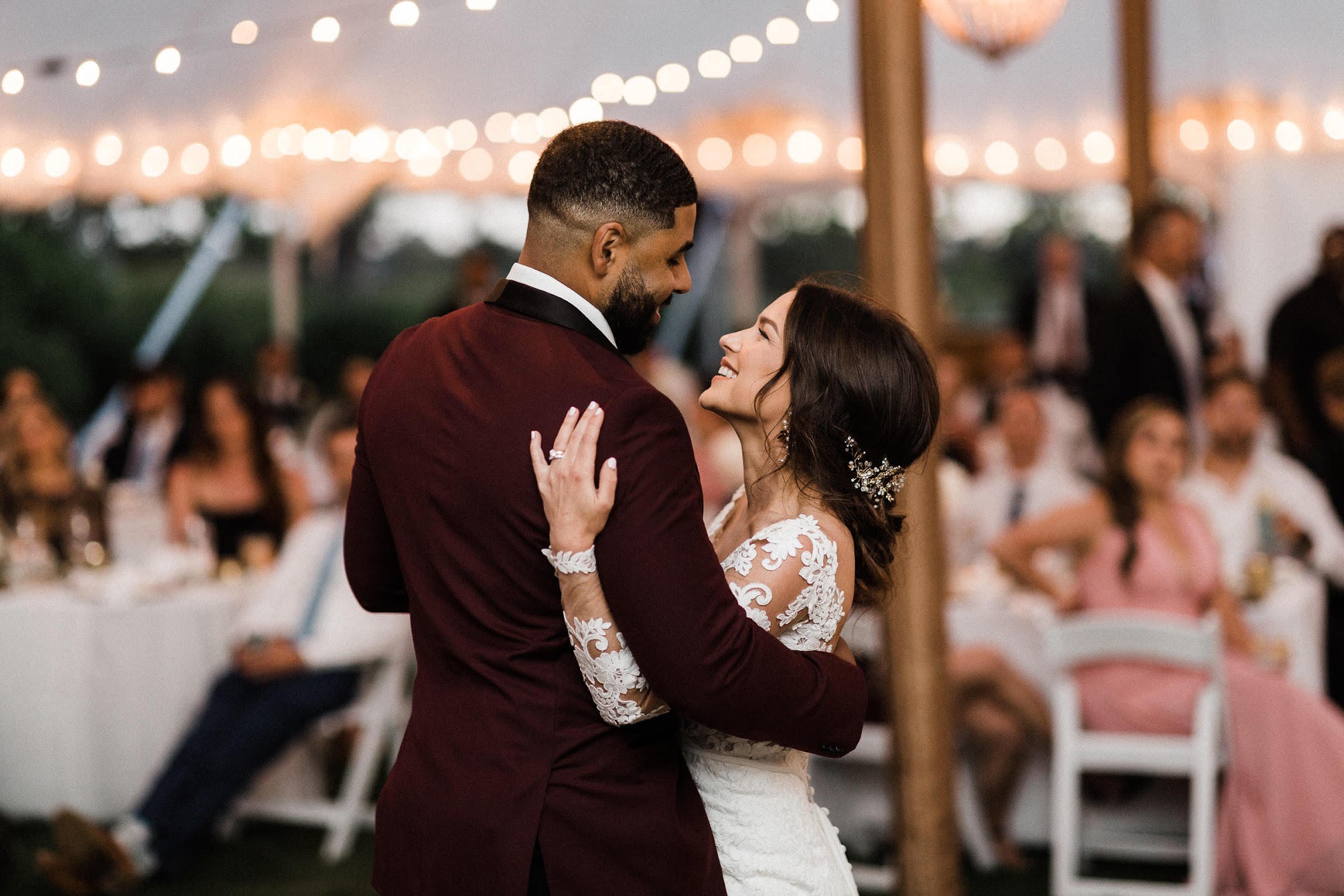bride and groom holding each other while dancing 