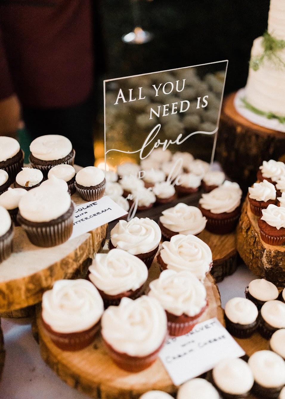 A bunch of mini cupcakes with an "All You Need Is Love" sign.