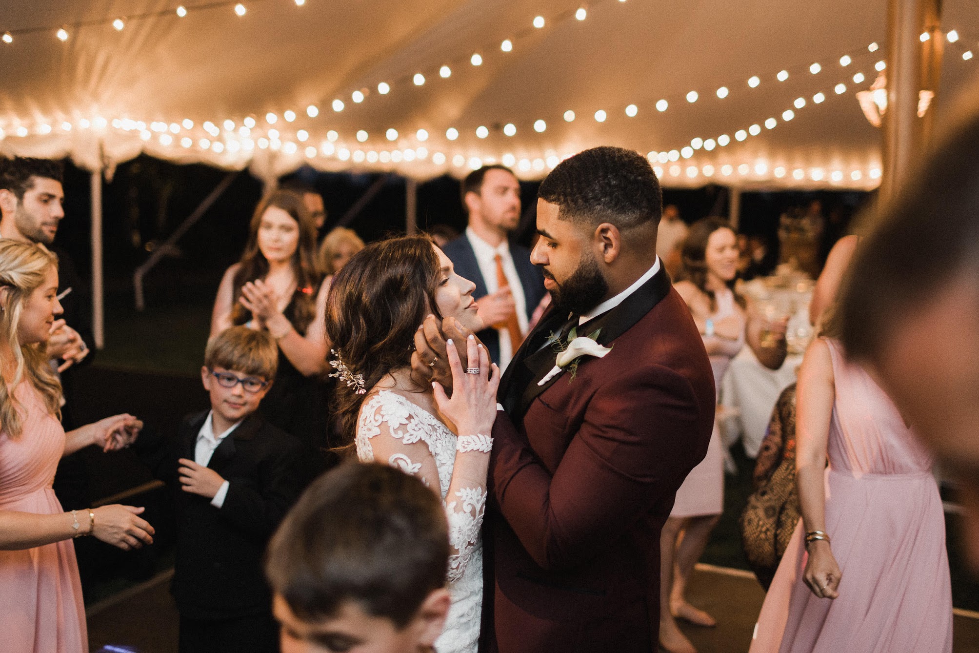the dance floor is full of people, but the bride and groom are just looking at each other while everyone else dances around them 