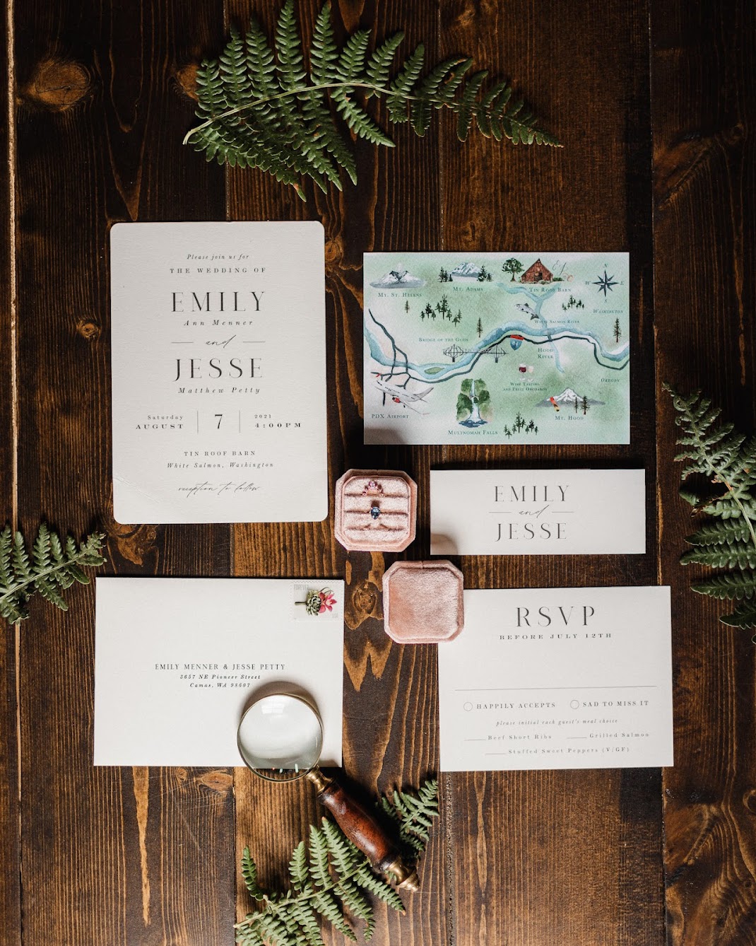 The wedding invitation suite invites guests to join the couple at Tin Roof Barn surrounded by ferns, and the wedding rings in the middle.