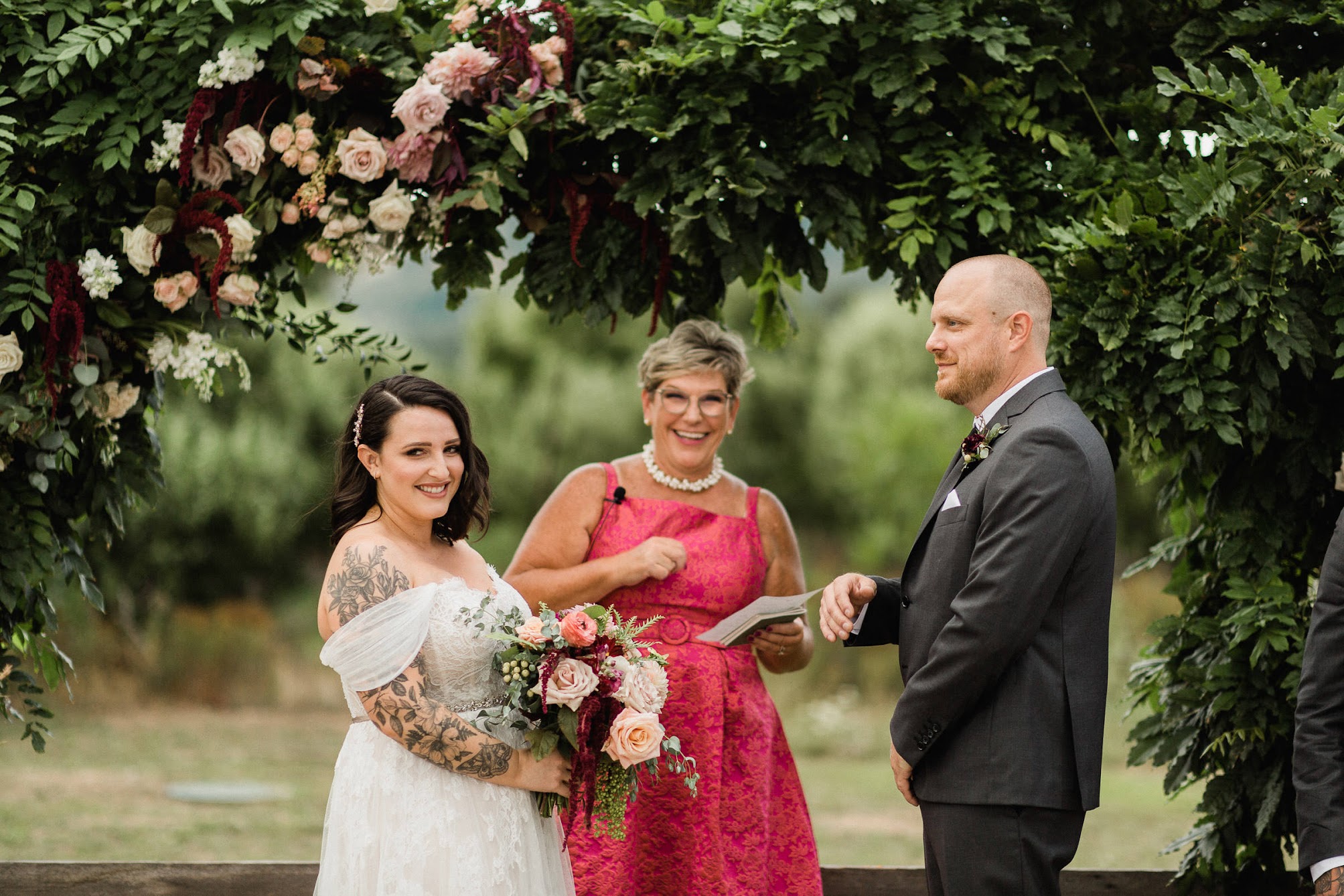 The bride laughing as the officiant tells a funny joke.