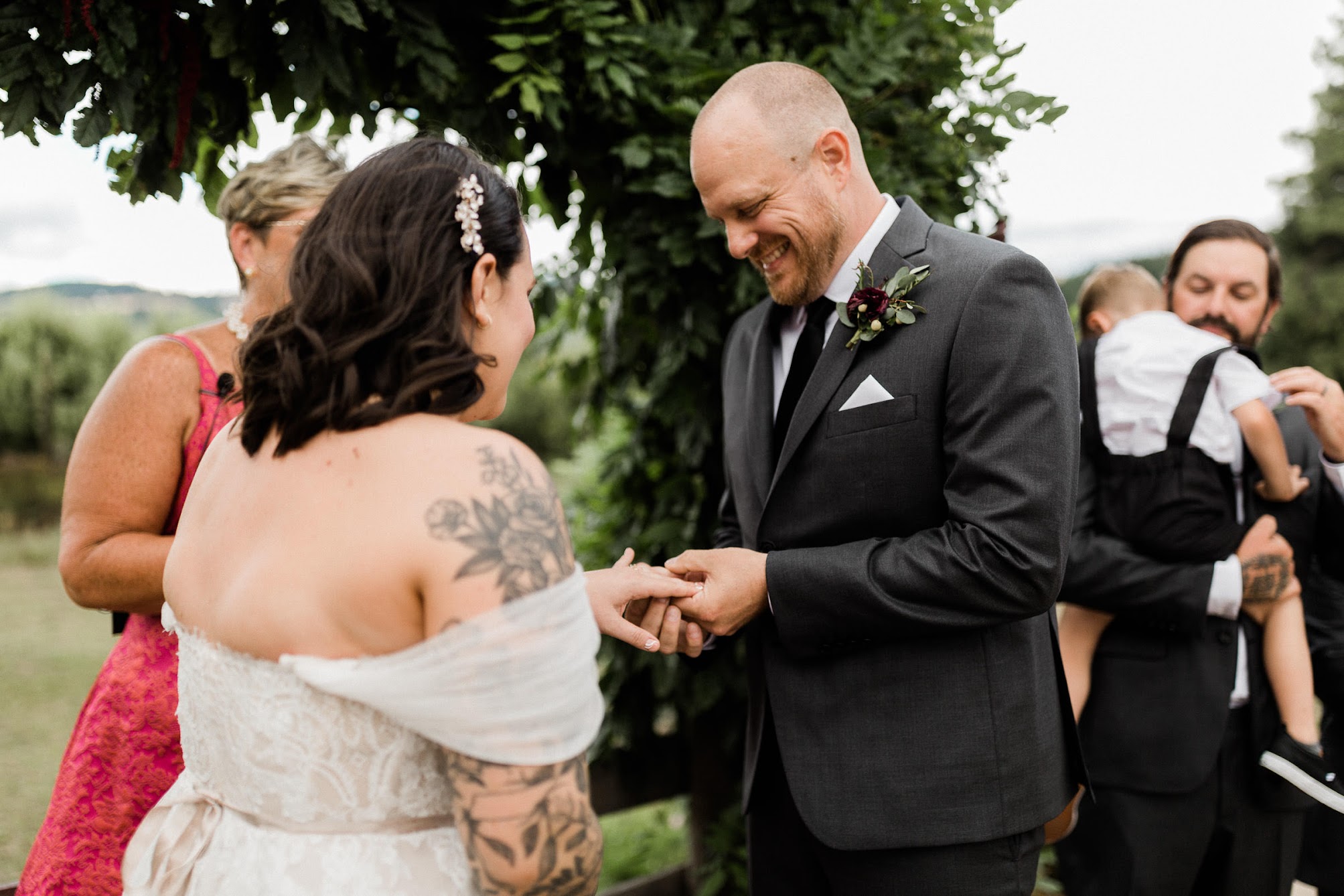The groom putting on his bride's wedding ring.
