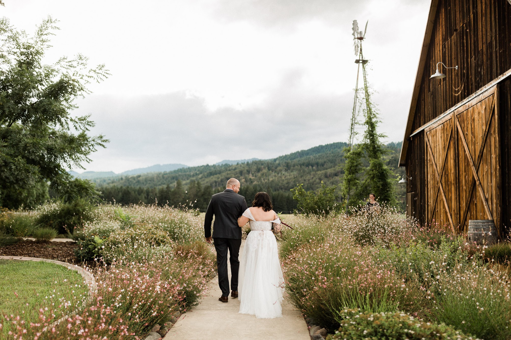 The bride and groom walk away towards the Mountains, arms locked together. 