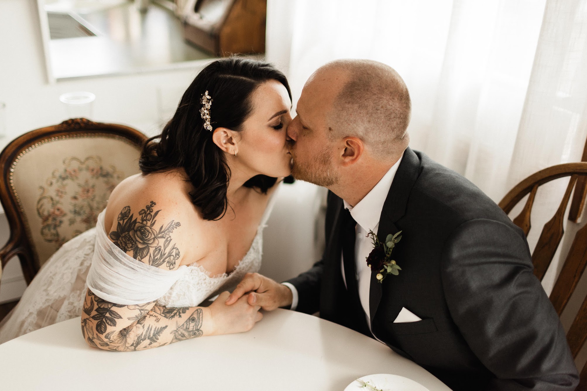 The bride and groom kissing each other while they sign their marriage License.