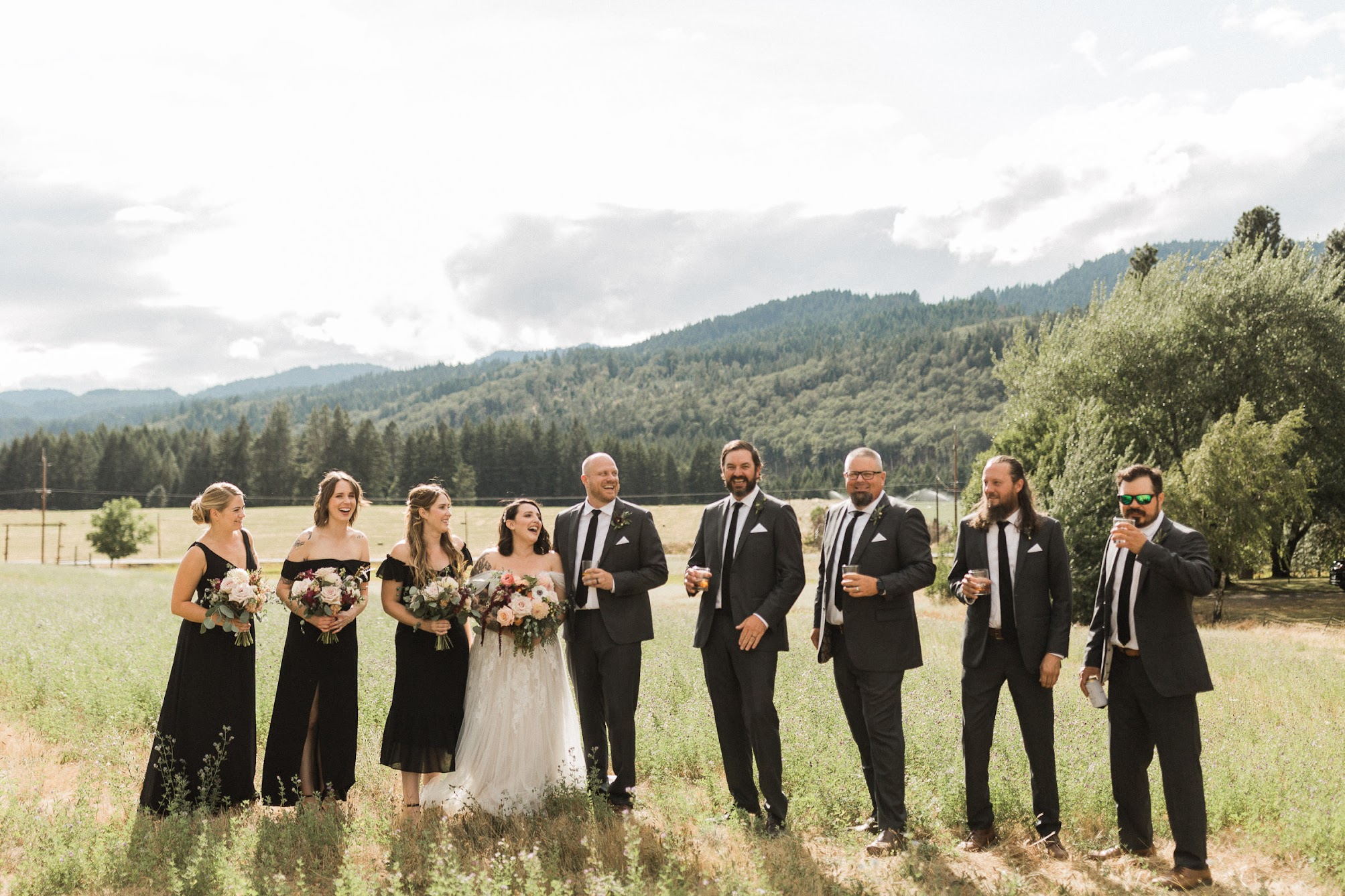 the bridal party lines up, girls holding their floral bouquets as the guys hold a beer.