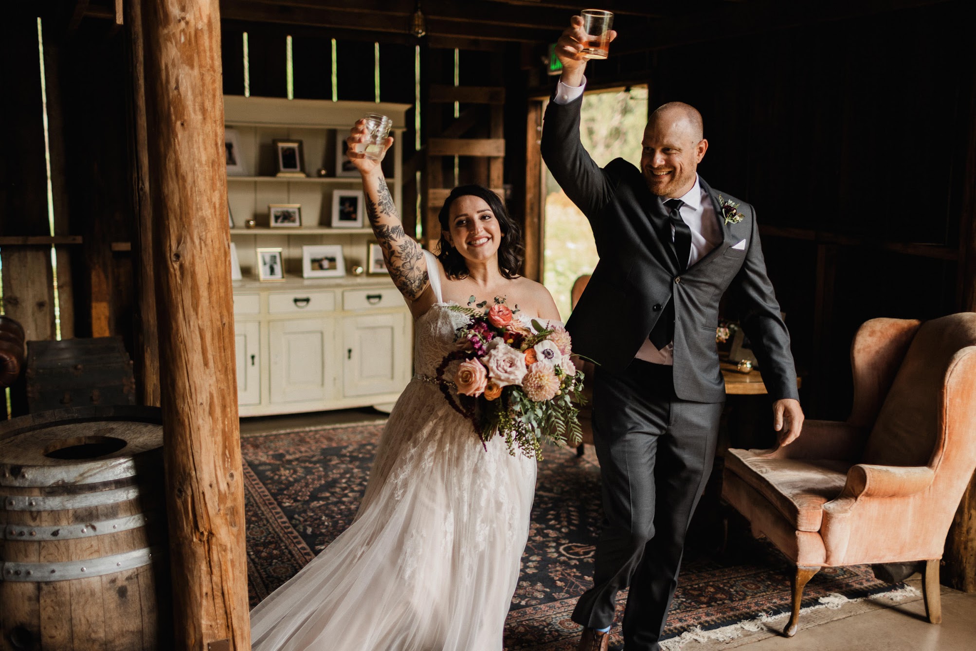 The couple entering their wedding reception with drinks in their hands