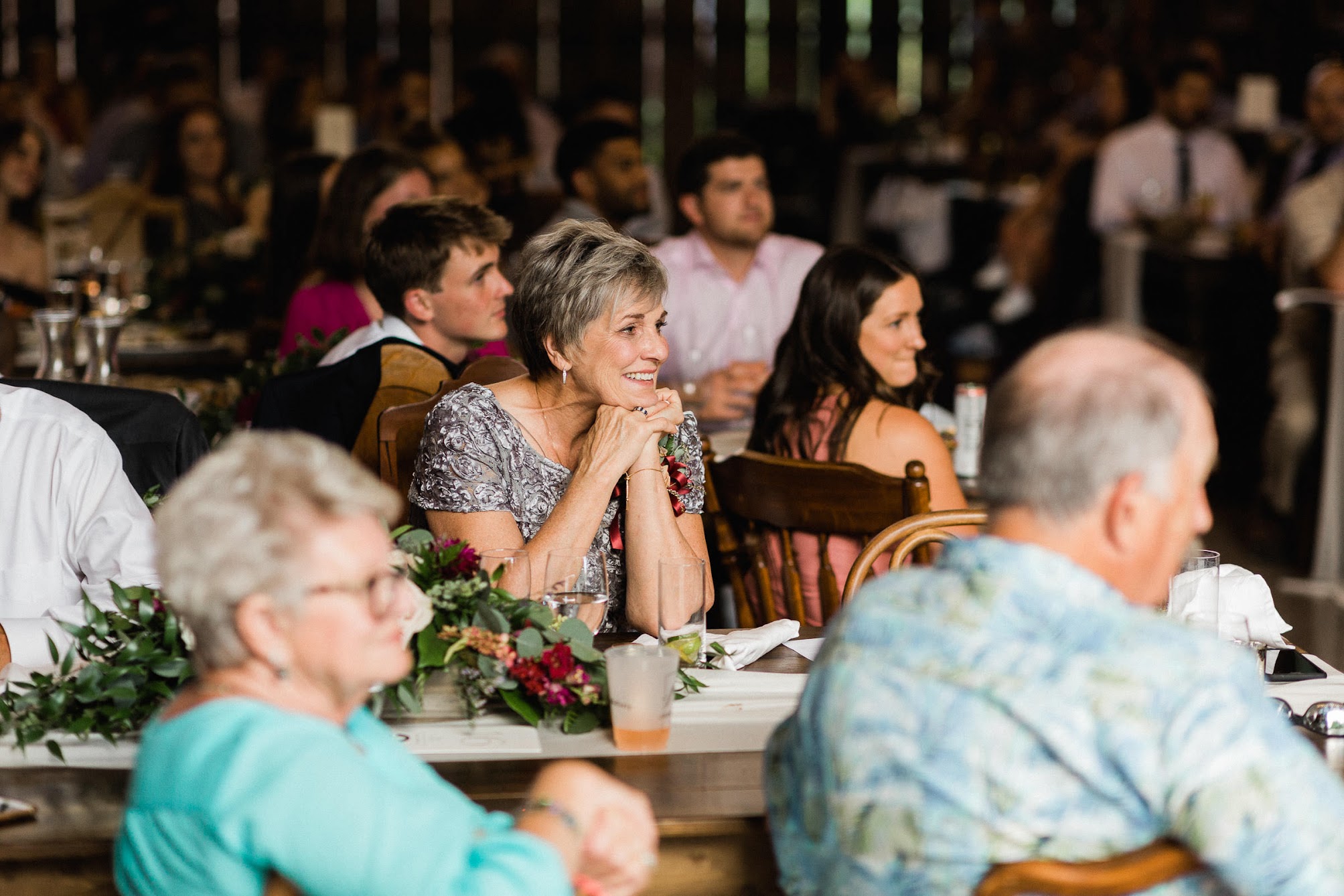 Family members sitting at their tables looking at the couple.