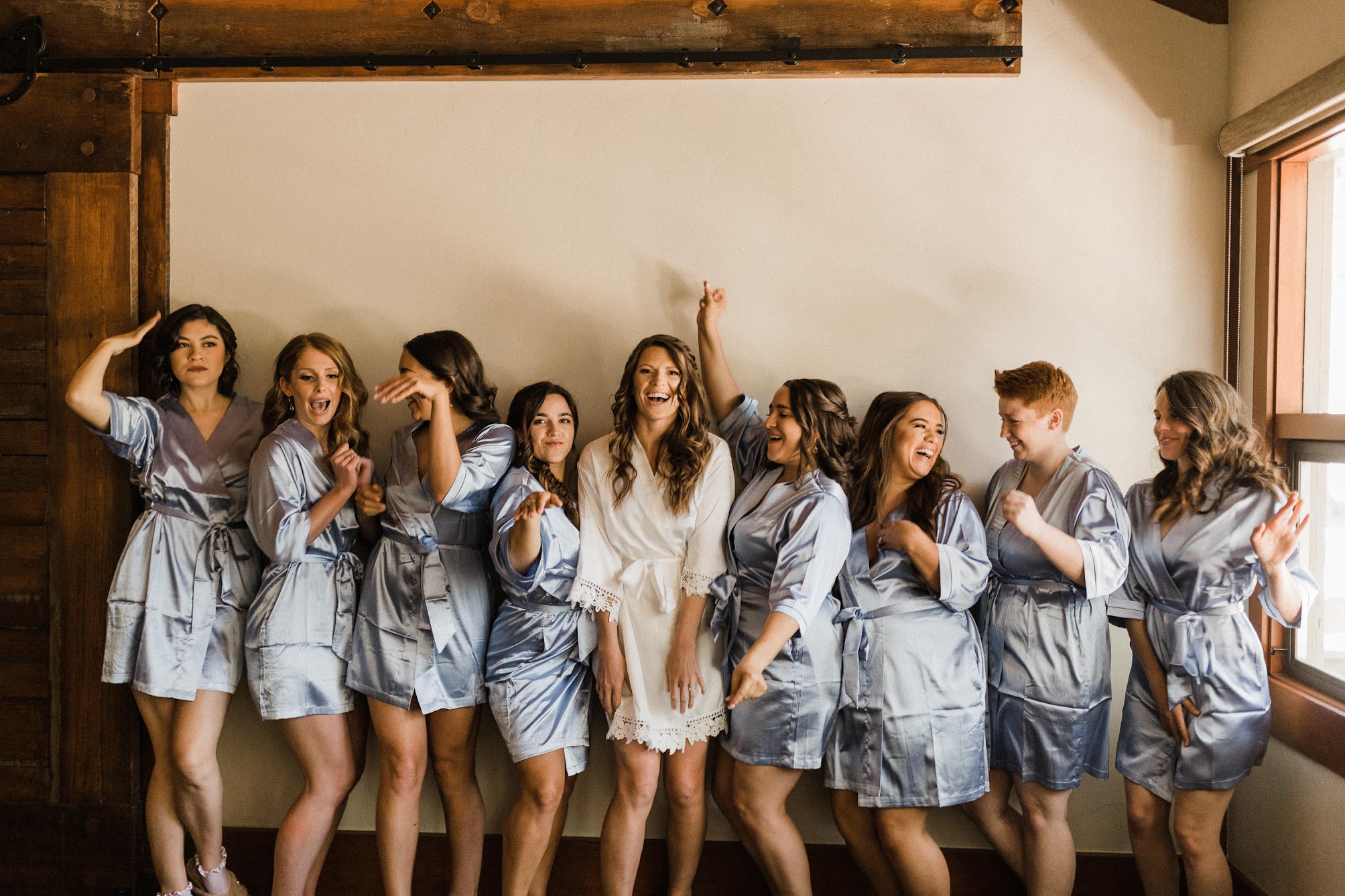 bride and her 8 bridesmaids in robes all-dancing. 