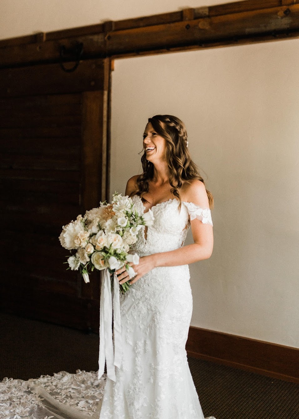 Bride smiling while holding her bouquet.