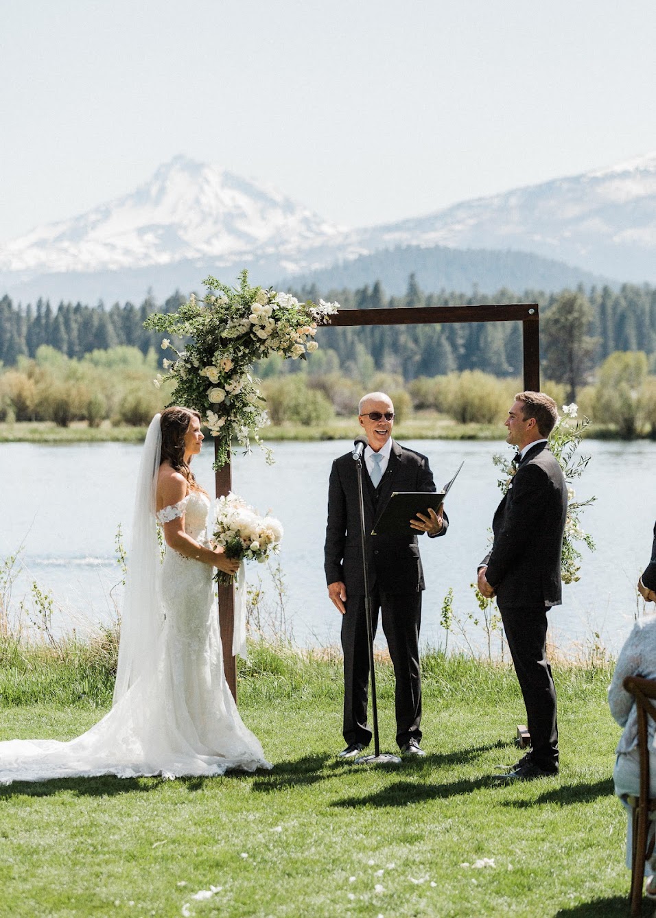 bride and groom standing at the arbor with the officiant 