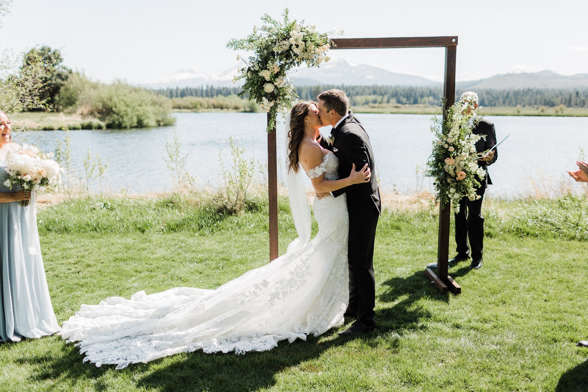 Bride and groom kissing under the arbor. 