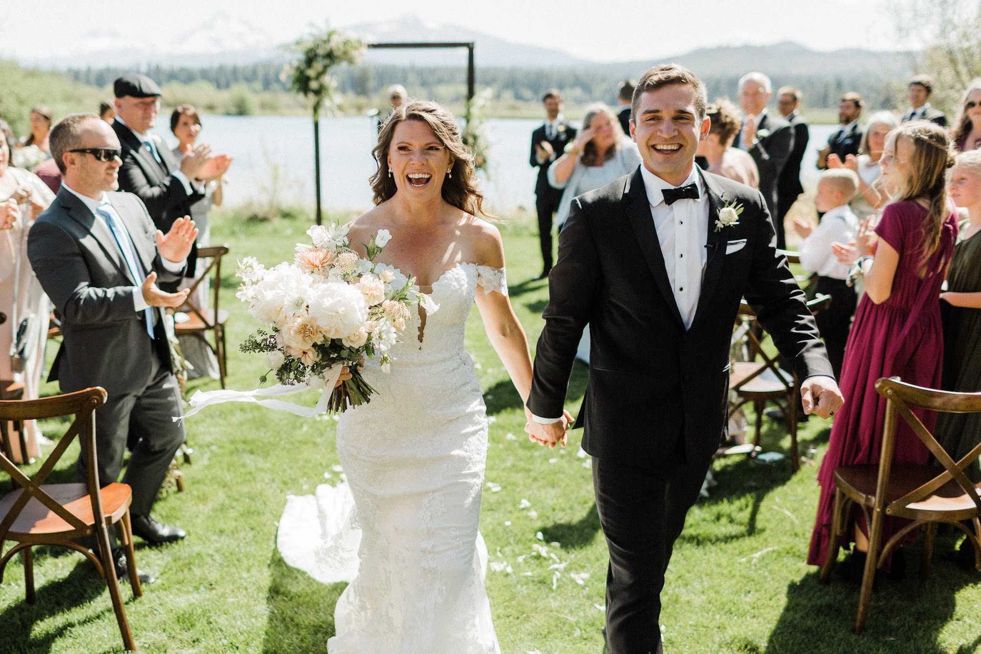 couple holding hands walking back down the aisle together 
