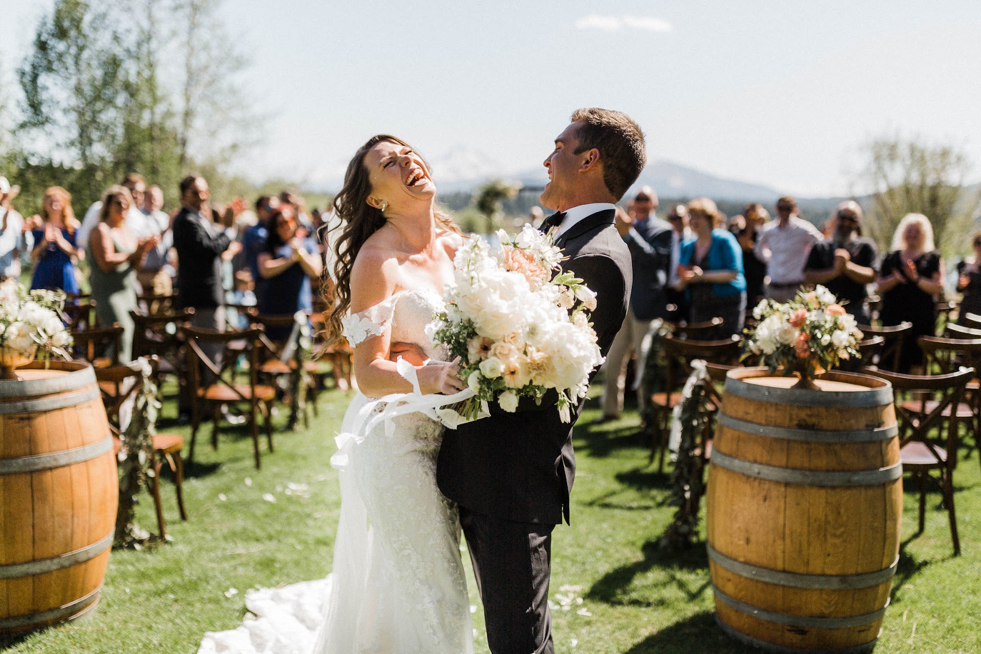 bride and groom laughing and holding each other. 