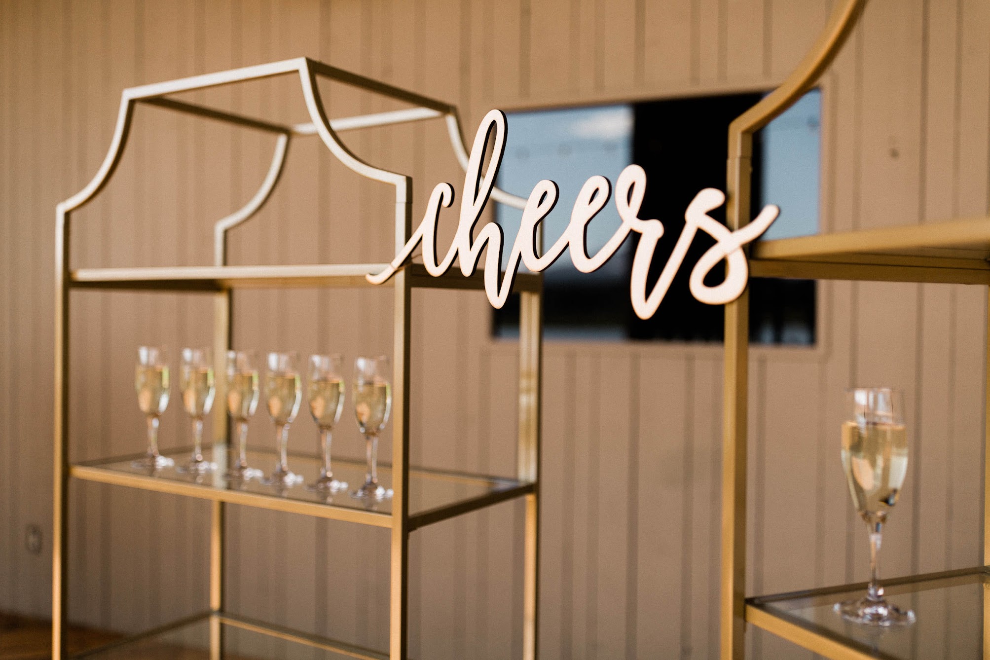 A sign that says "Cheers" with champagne glasses 