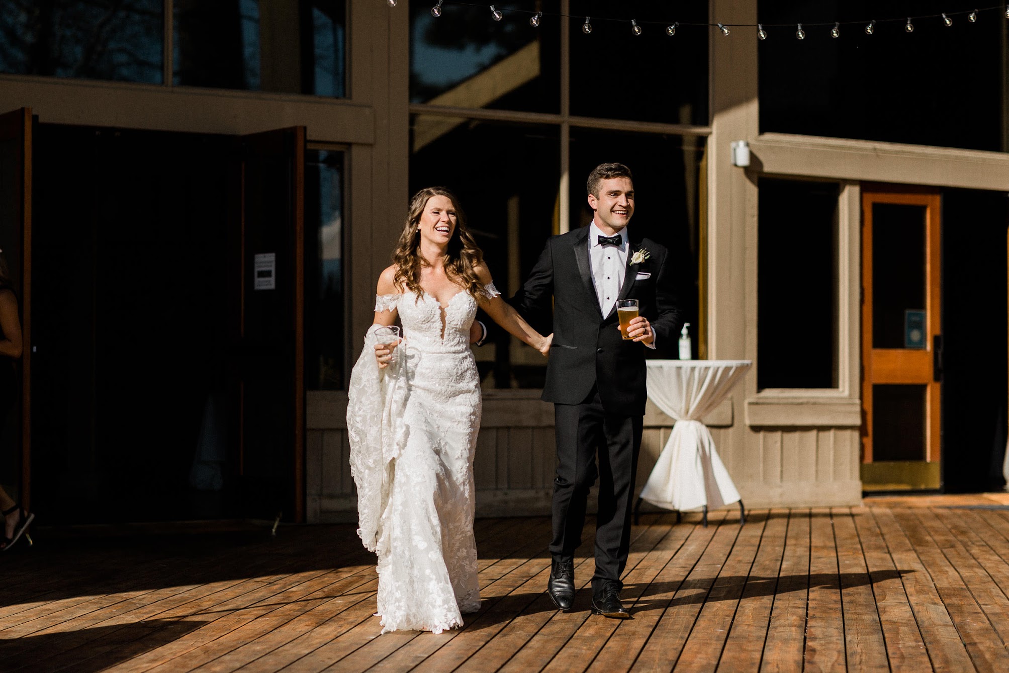 bride and groom walking into cocktail hour together 